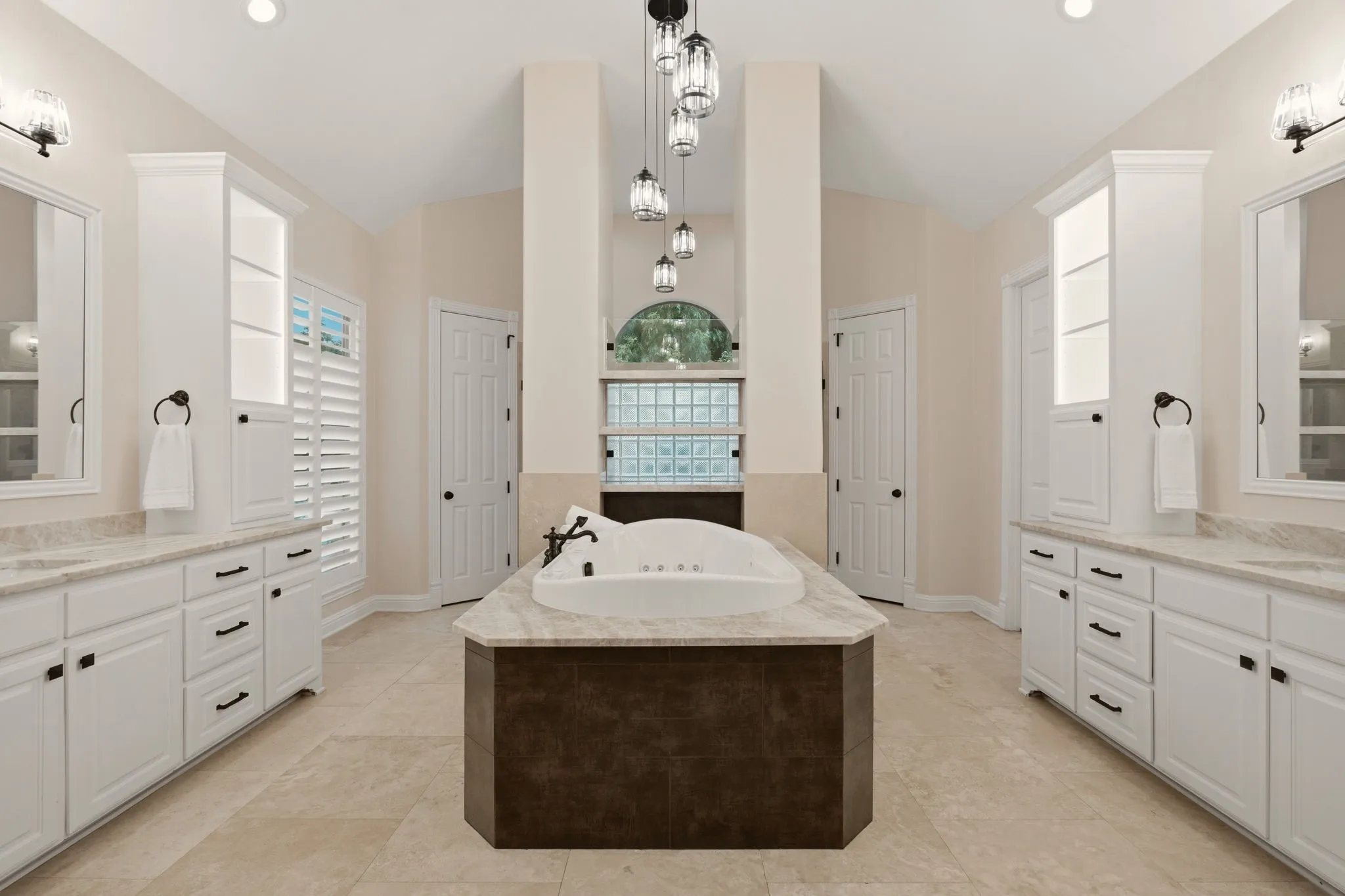 The remodeled primary bath is defined by clean lines & thoughtfully chosen finishes. Fusion Quartzite countertops adorn the vast amount of cabinets.  Noteworthy tiered pendant lighting over the deep Jetta Jacuzzi luxury spa tub with hydro & action jets. A true spa experience! His & hers walk-in closets too.
