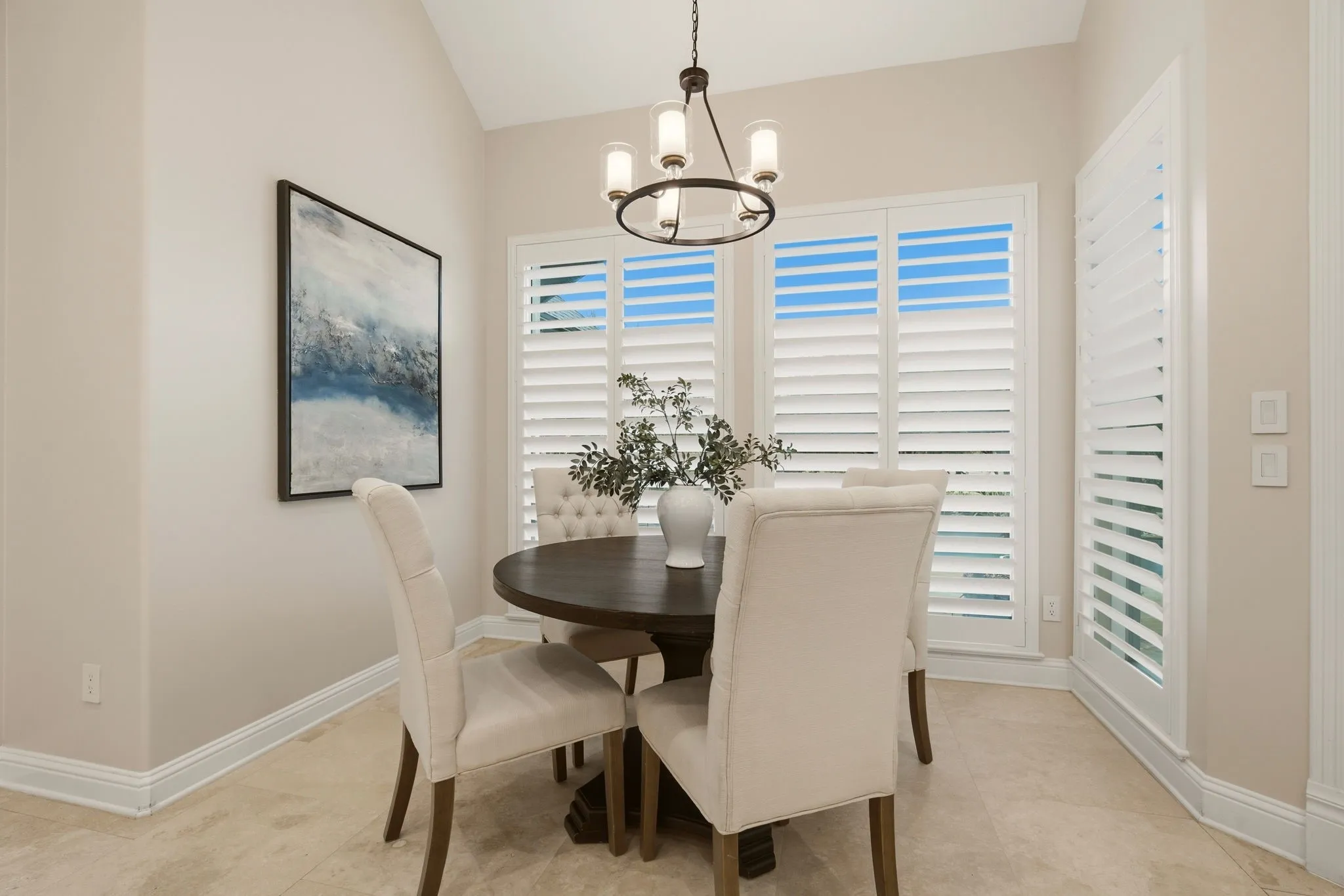 The breakfast nook is a bright, inviting space for morning coffee or casual meals. Plantation shutters with hidden title rods grace the picture windows ~ all facing the swimming pool & lushly landscaped yard.