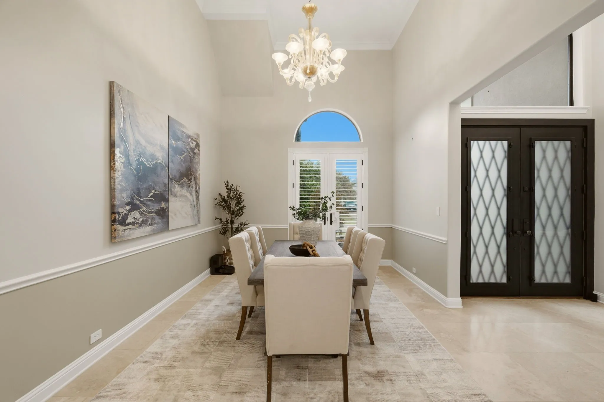 Featuring a formal dining room designed to accommodate any table shape, making it ideal for both intimate dinners or larger gatherings. Note the stunning multi-tiered Murano glass chandelier, with a complimentary one in the foyer.