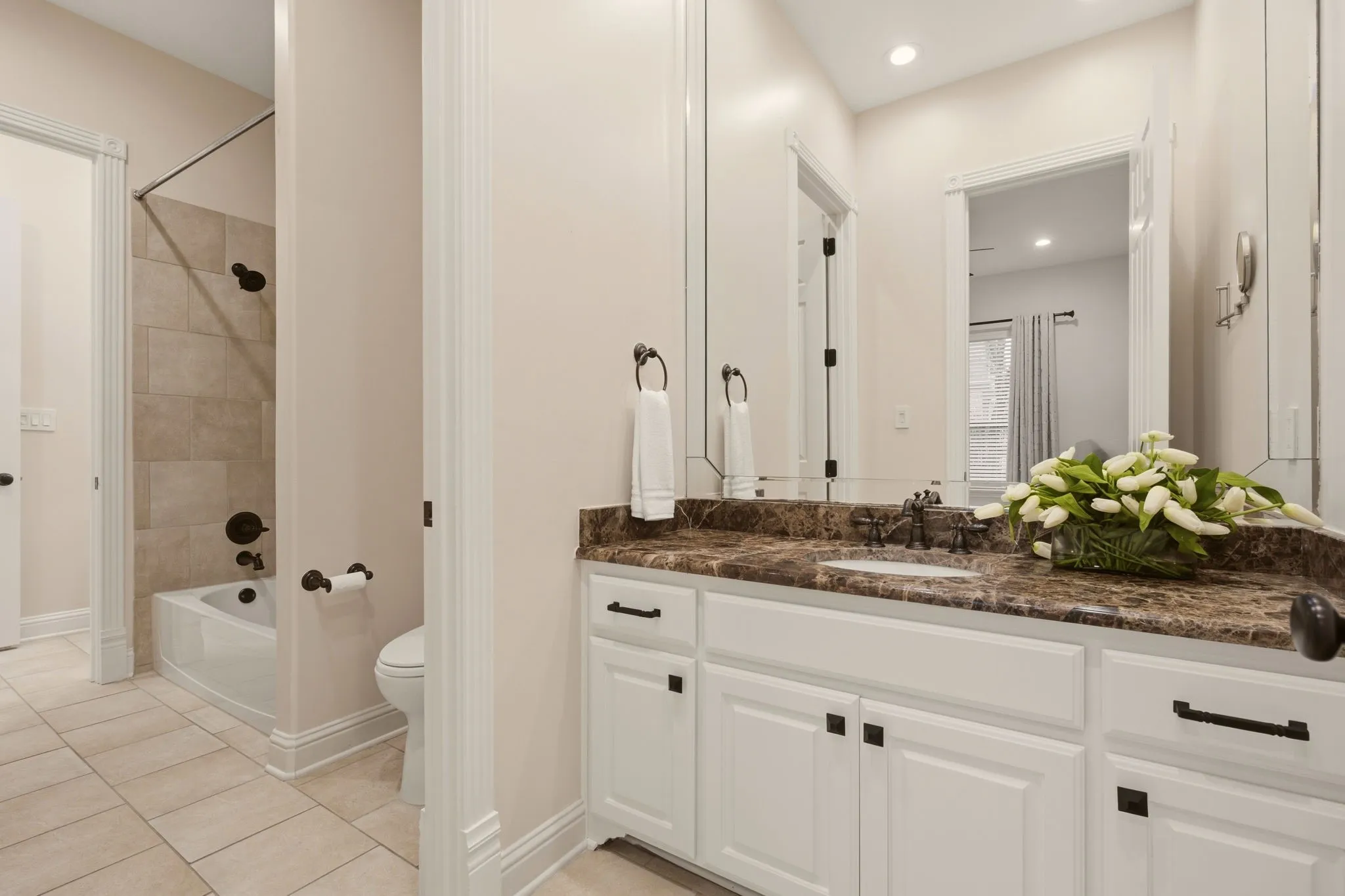 Shared full bath between bedrooms 3 & 4, each with a wide granite countertop & ample storage.