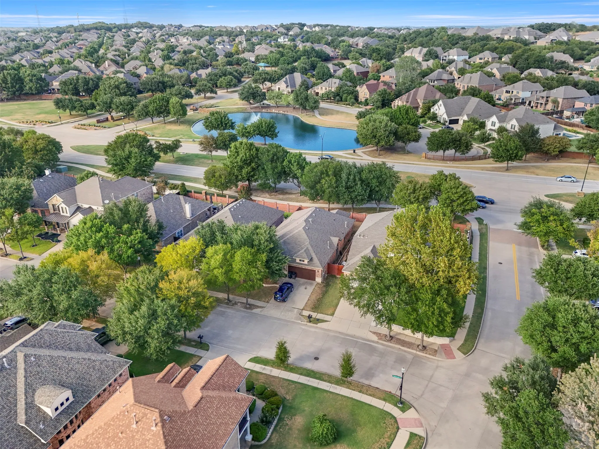 Residential neighborhood with mature trees and a central pond feature