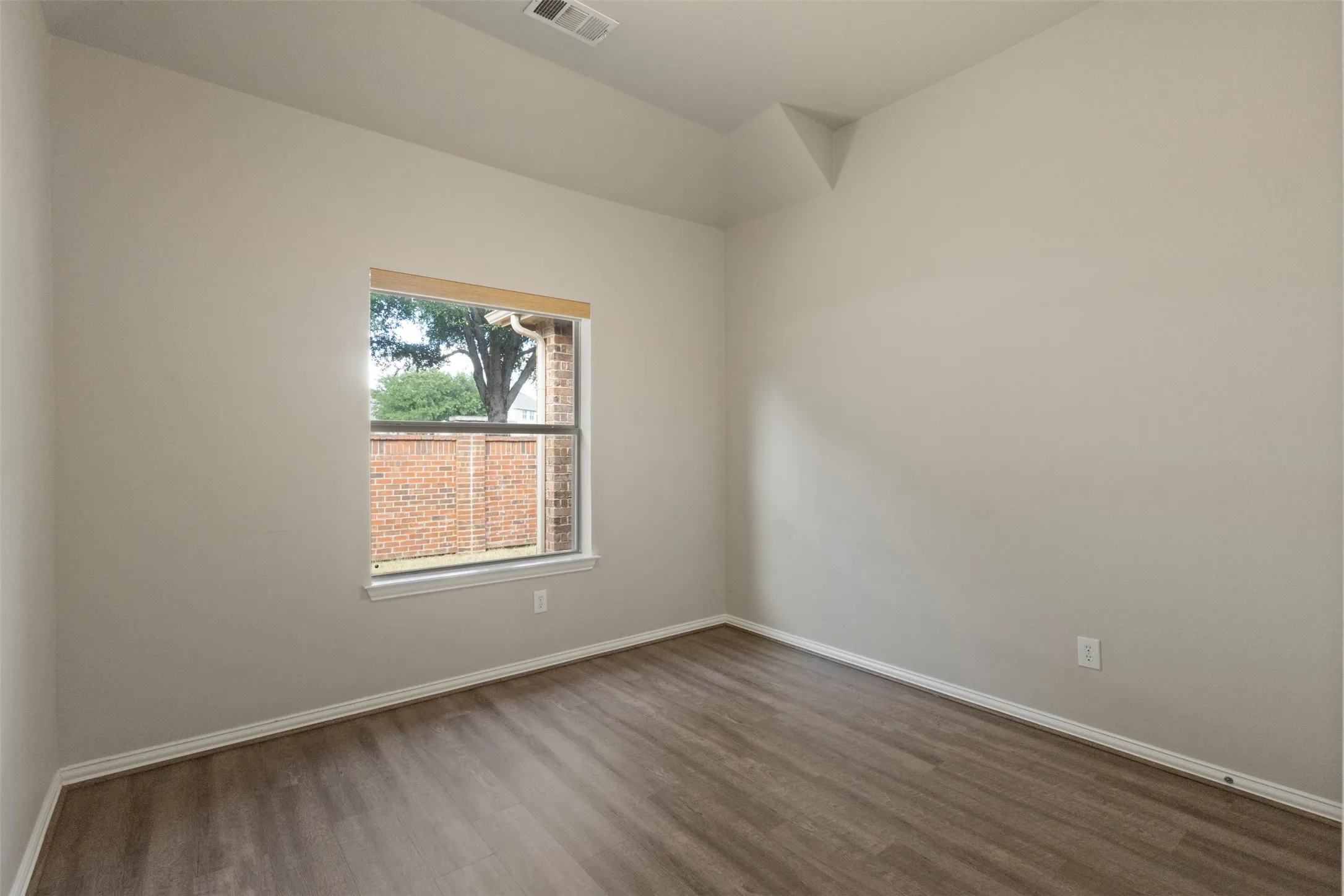 Recessed ceiling detail, wood-finish flooring, white window trim, and white baseboards