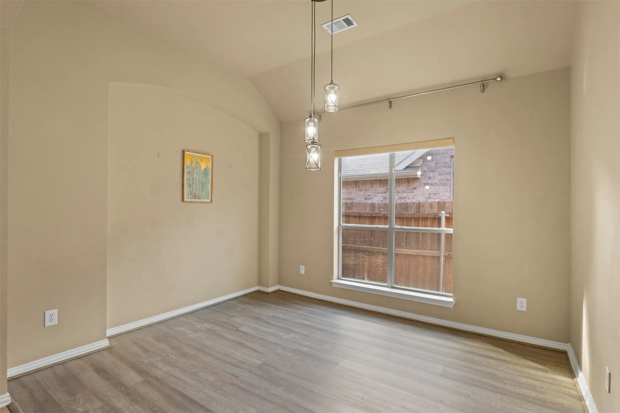Vance-style flooring, vaulted ceiling, arched doorway, recessed lighting, and a large window