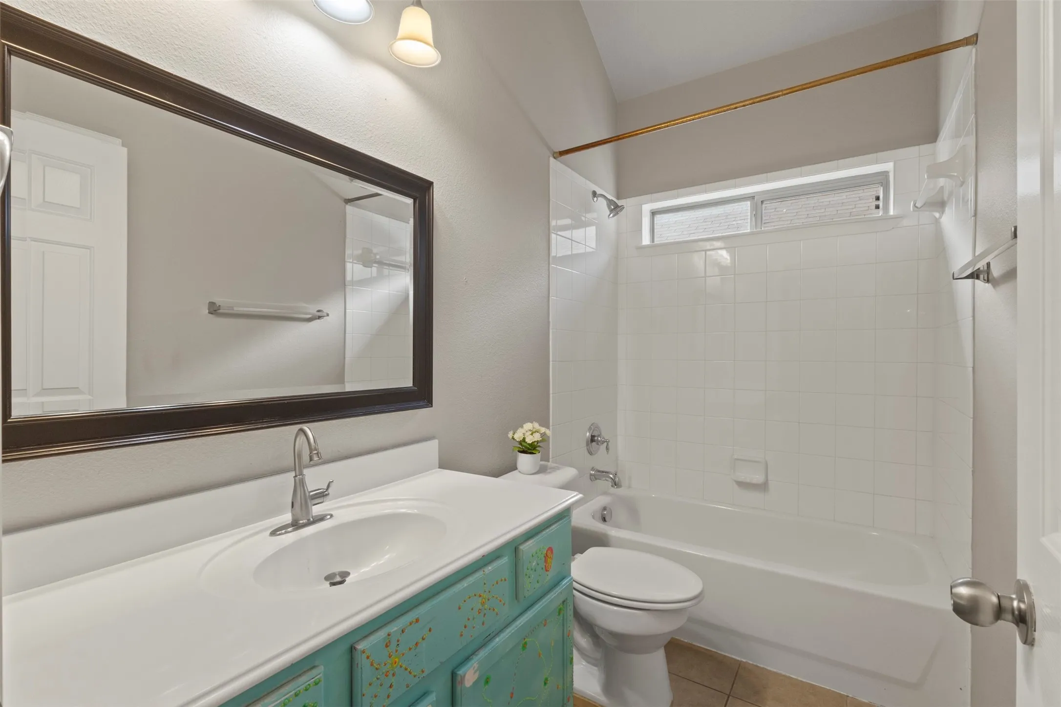 Integrated vanity with an undermount sink, a framed mirror, and a full-size bathtub with white tile surround