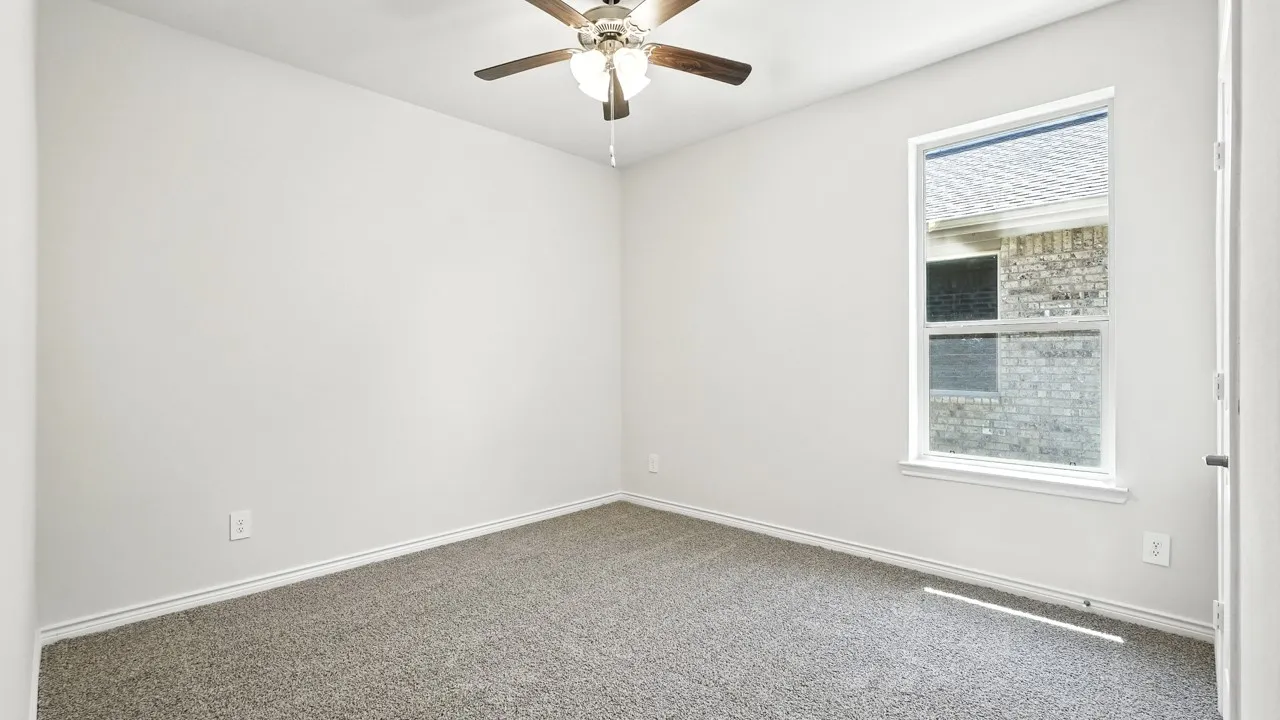Room featuring neutral carpet flooring, light-toned walls, and a ceiling fan with light fixture
