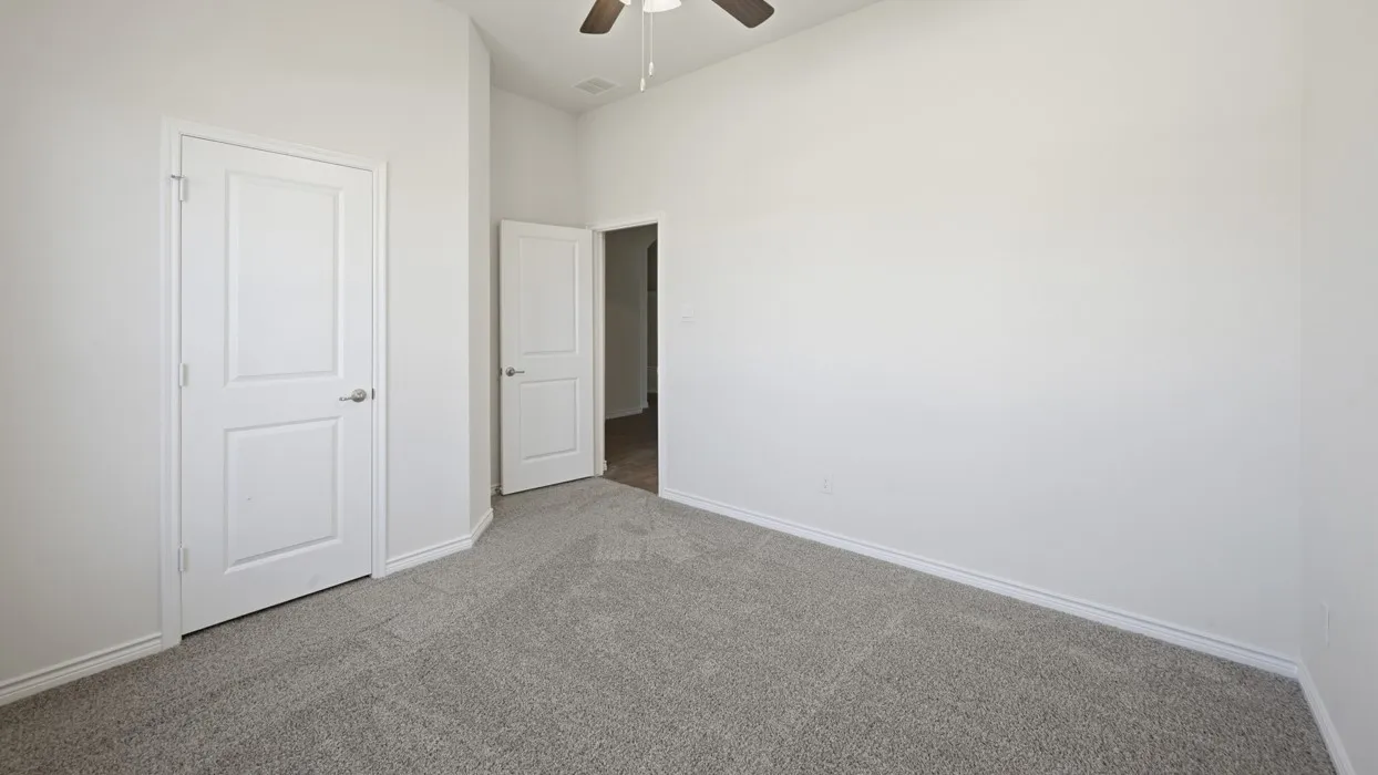 Bedroom featuring neutral grey carpeting, white baseboards, and bright white walls