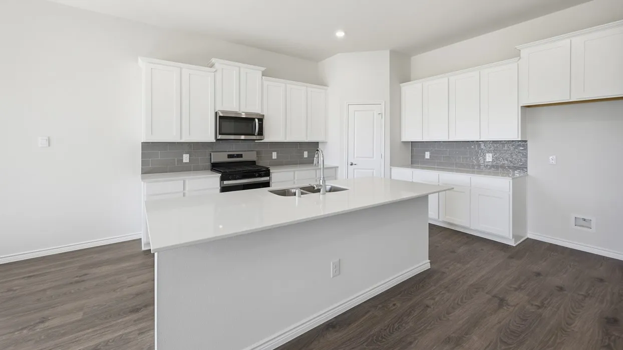 White cabinetry kitchen featuring a large island with a double basin sink, stainless steel microwave, gas range, and wood-finish flooring