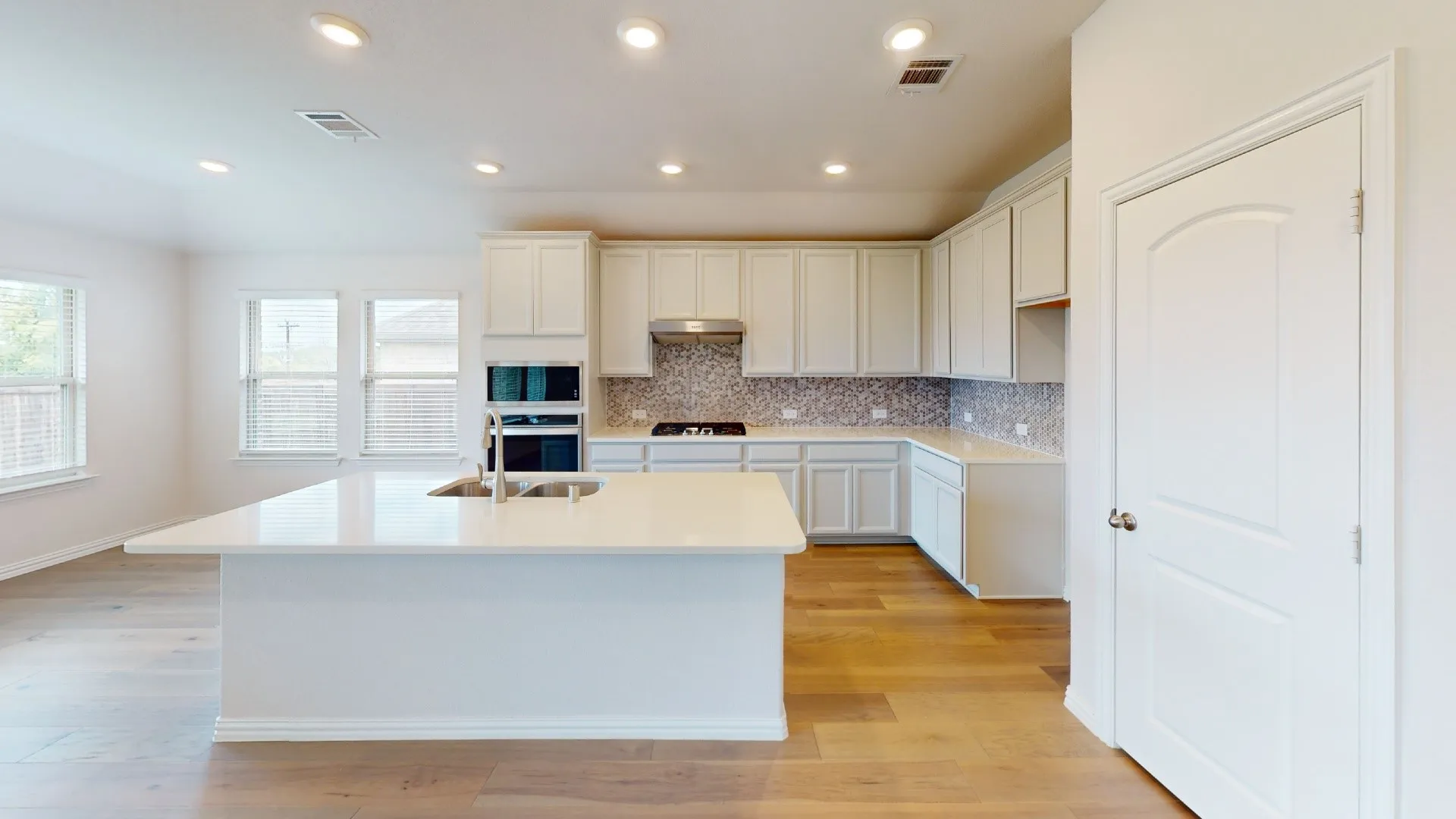 Expansive kitchen island with an undermount sink and contemporary faucet