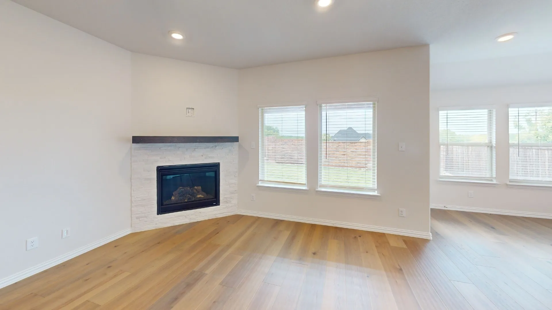 Corner fireplace with a stone surround and wood mantel