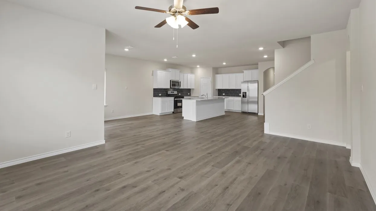 Open-concept living space featuring wood-finish flooring, recessed lighting, and a ceiling fan