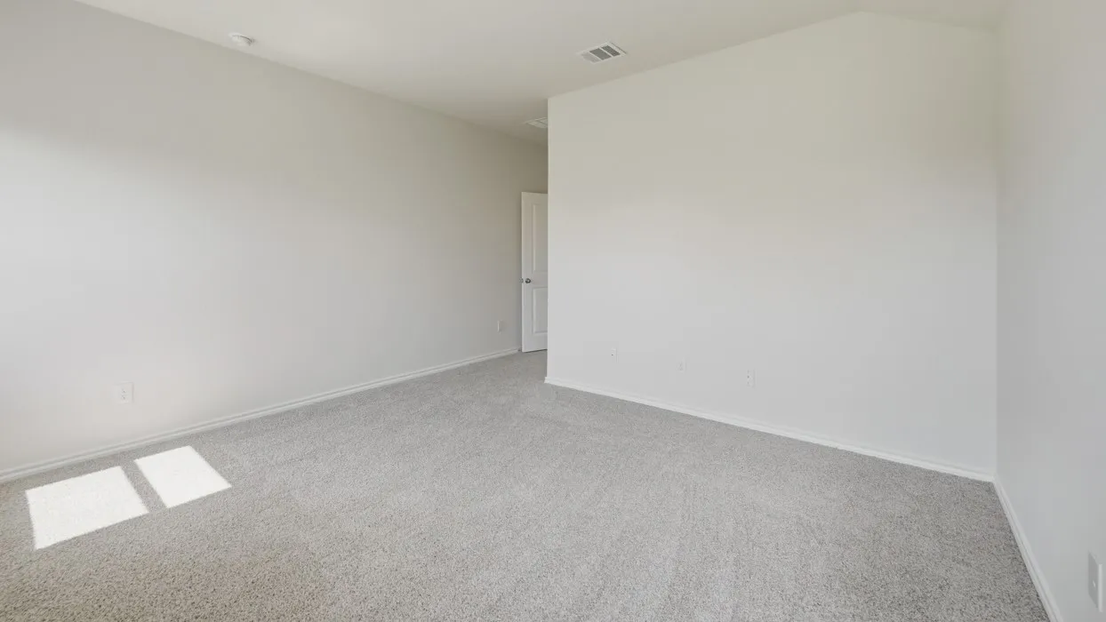 Spacious room featuring light gray carpeting, neutral wall finishes, white trim, and a white interior door