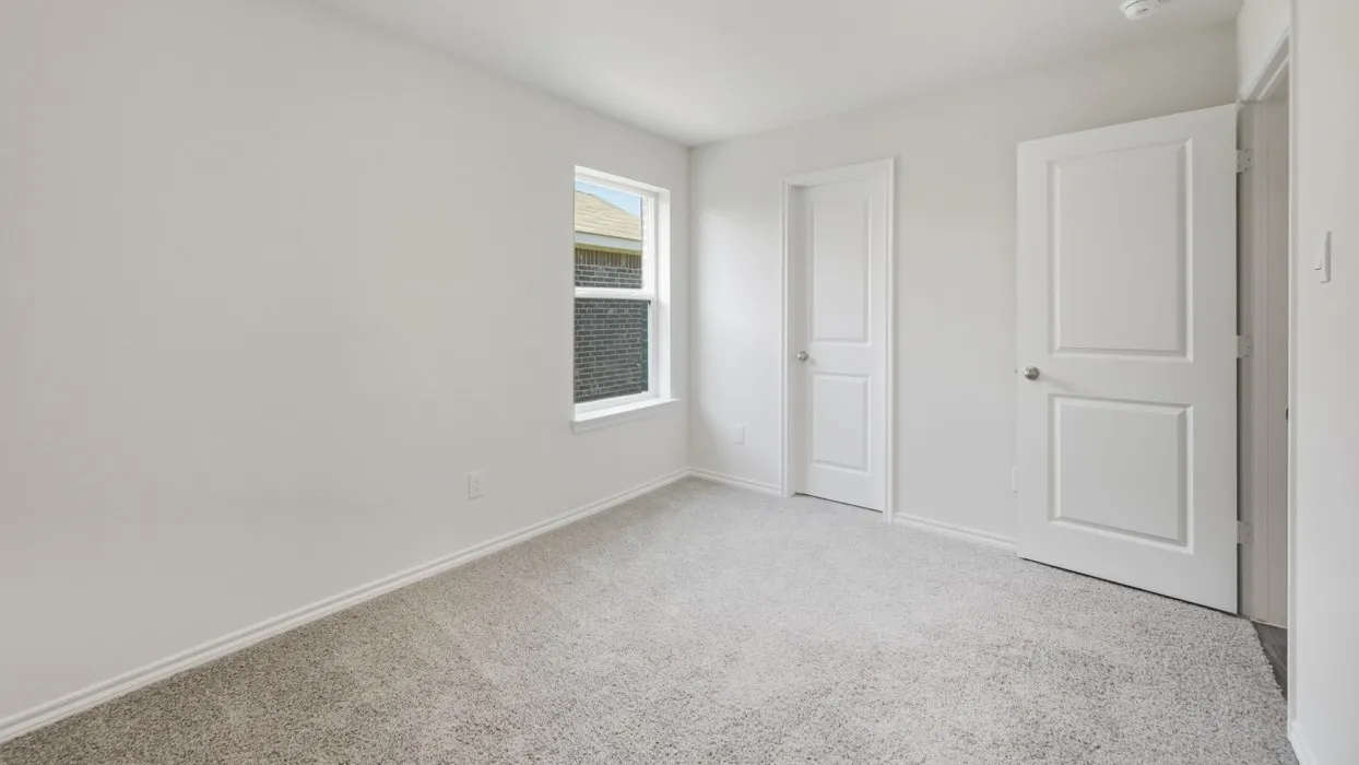 Spacious room featuring light gray carpeting, neutral wall paint, white trim, and two large windows offering ample natural illumination