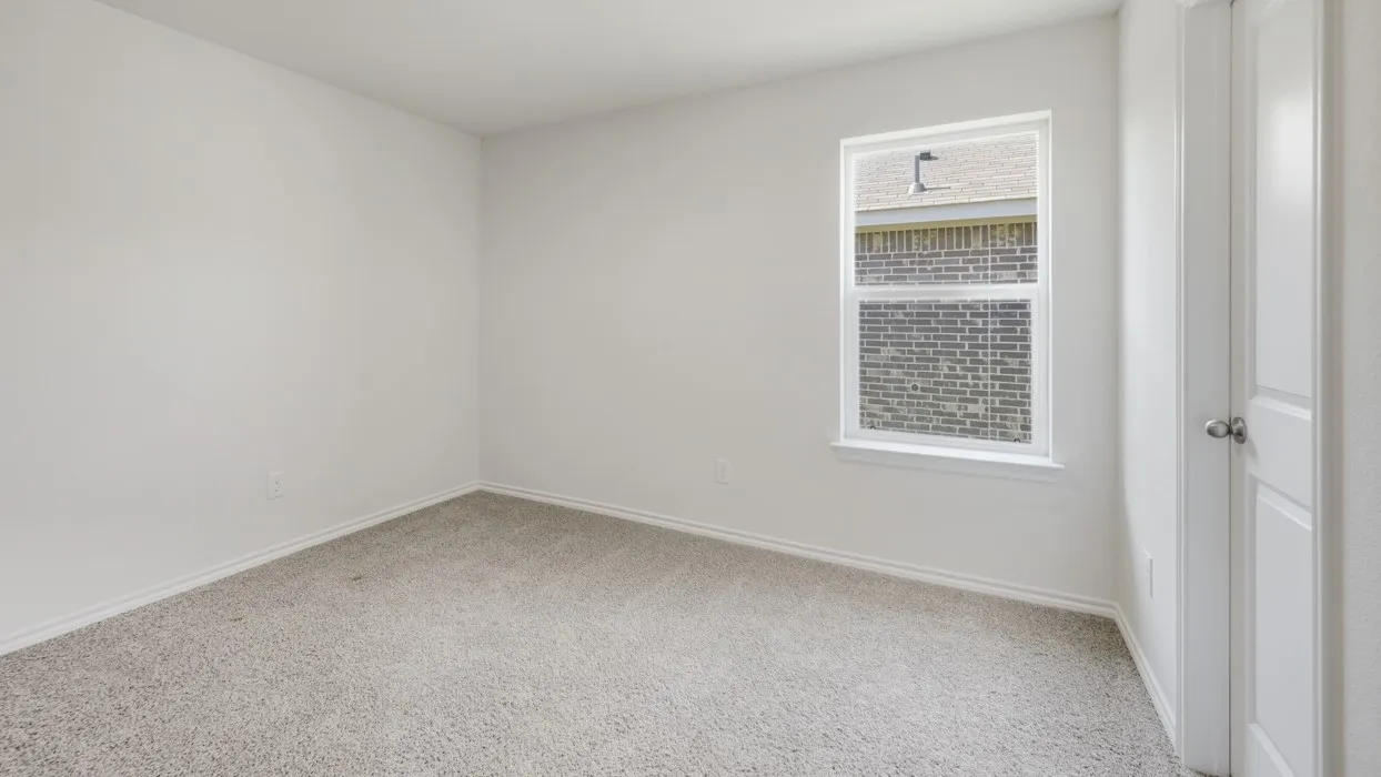 Spacious room featuring neutral carpeting, white walls, and a white-framed window