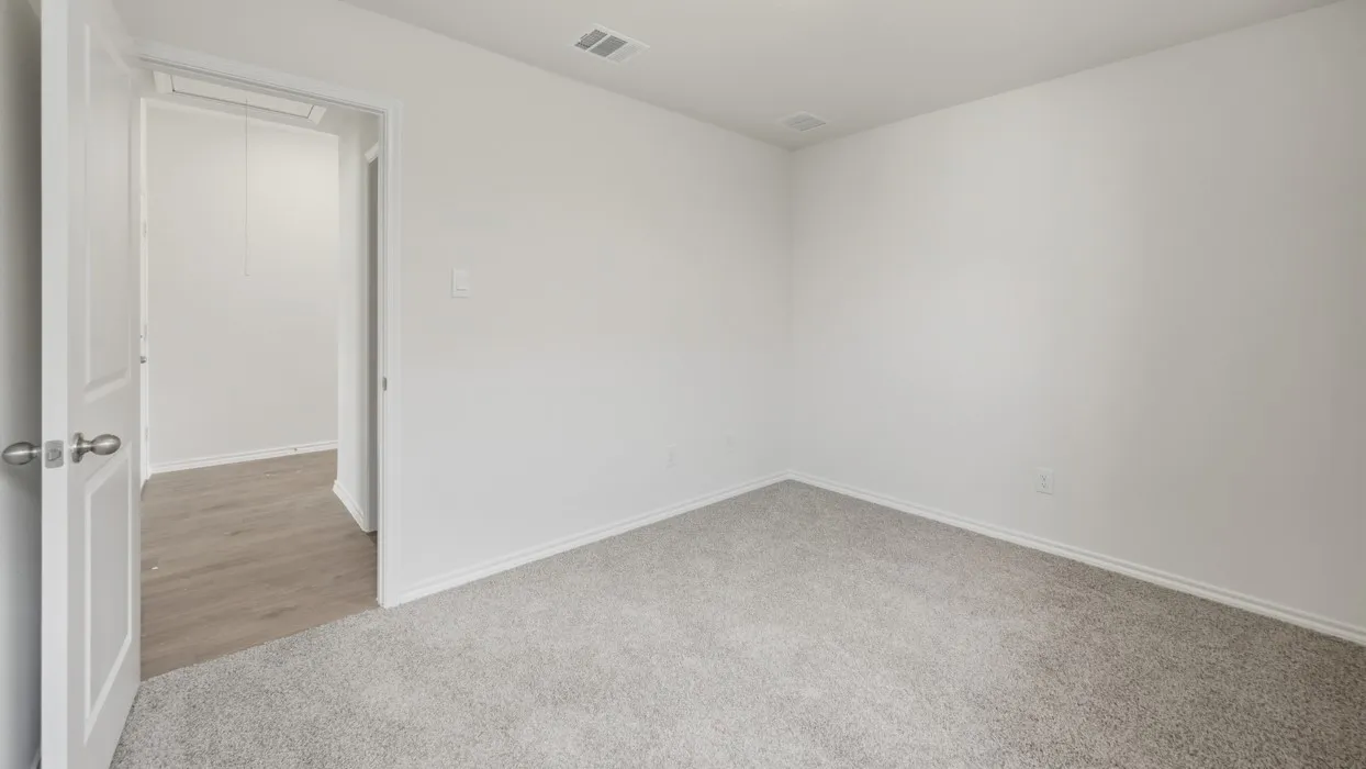 Interior room featuring light gray carpet flooring, white painted walls, and white baseboards