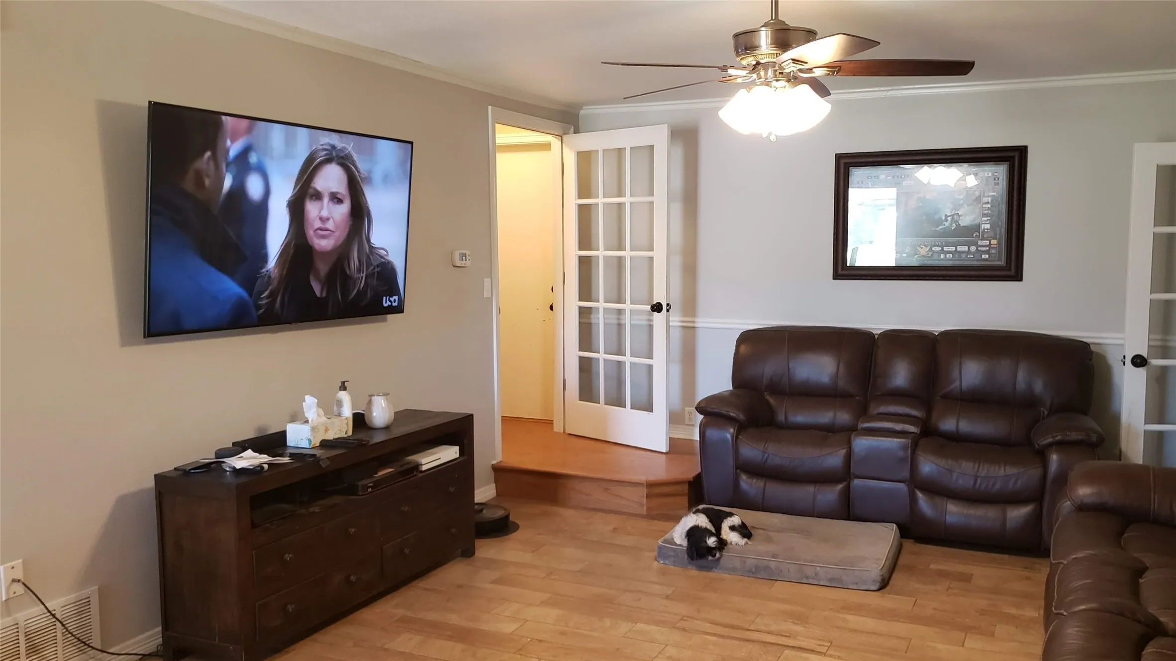 Hardwood flooring, crown molding, chair rail molding, ceiling fan, and French doors