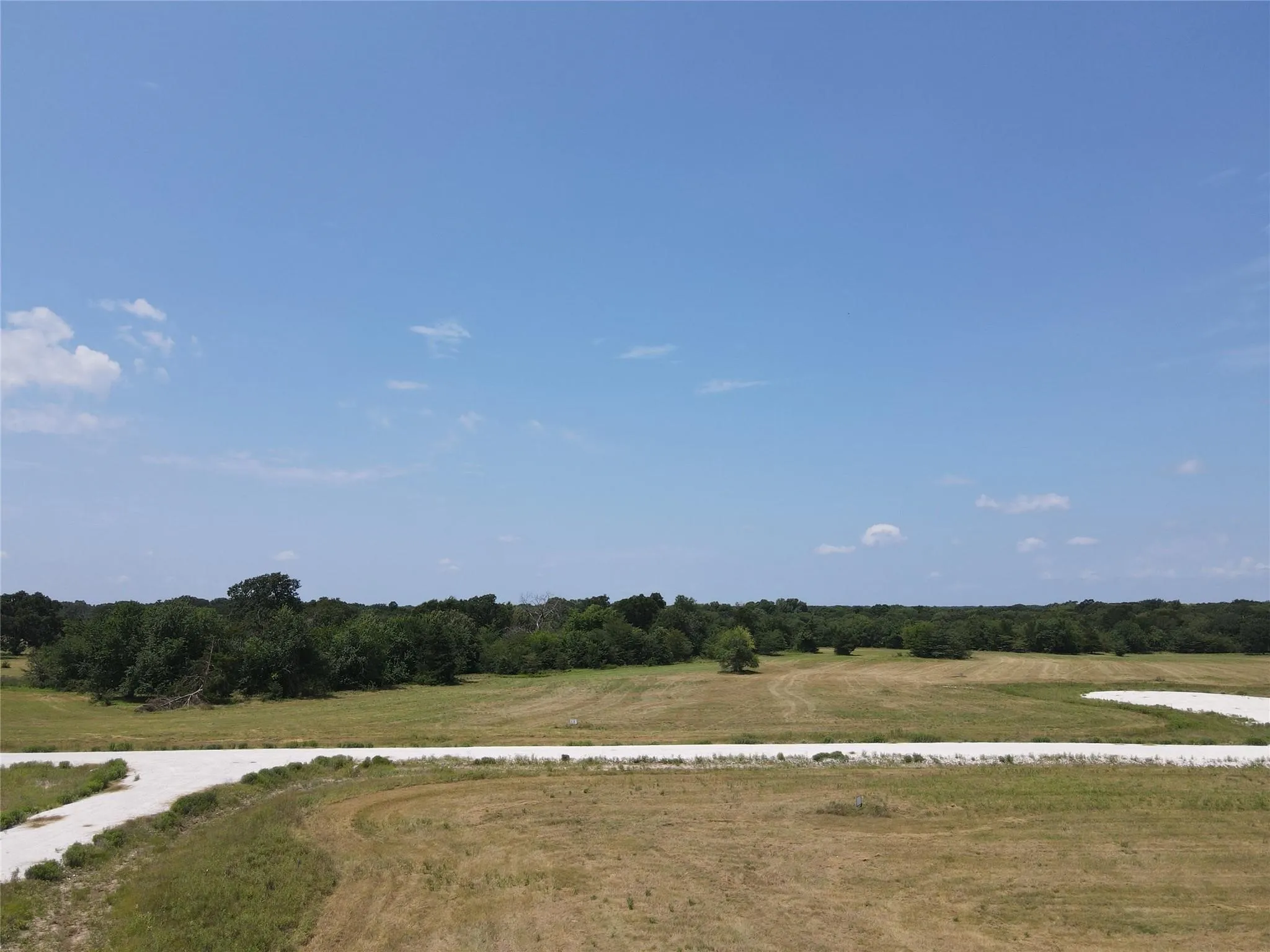 Expansive land parcel with natural terrain and scattered trees