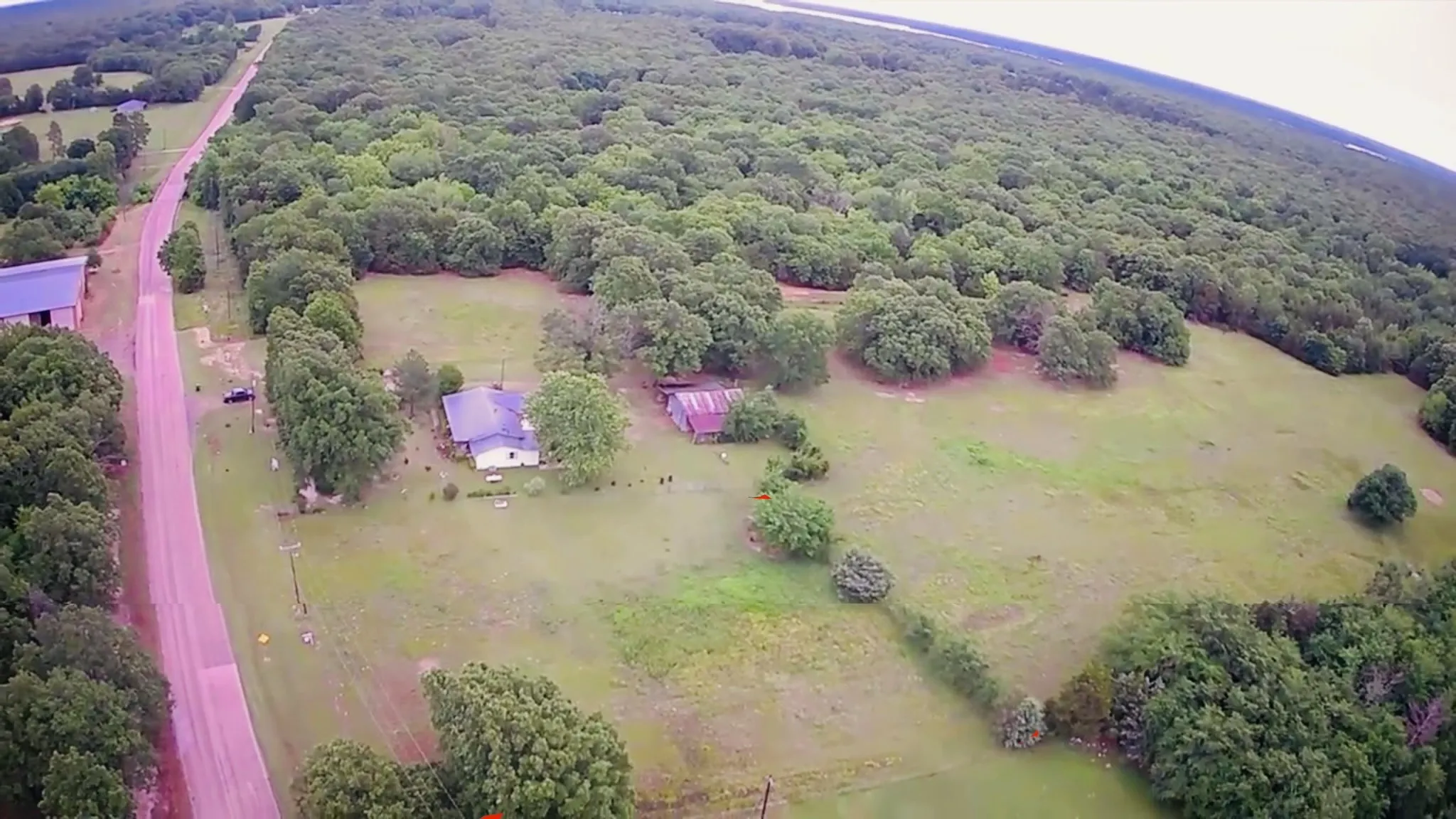 Expansive property with a residential structure, a secondary structure, and a large open field area