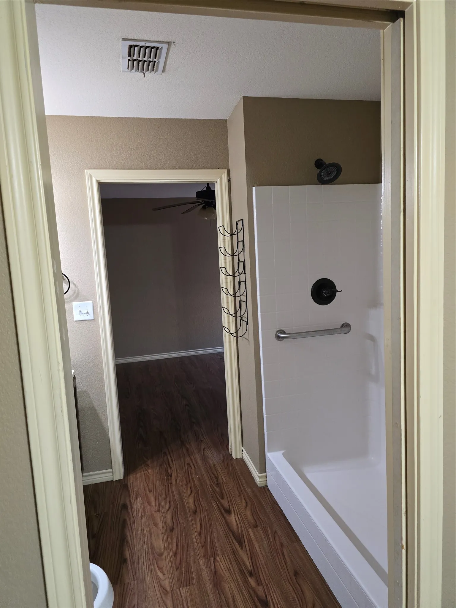 Shower with a grab bar and dark-finish fixtures