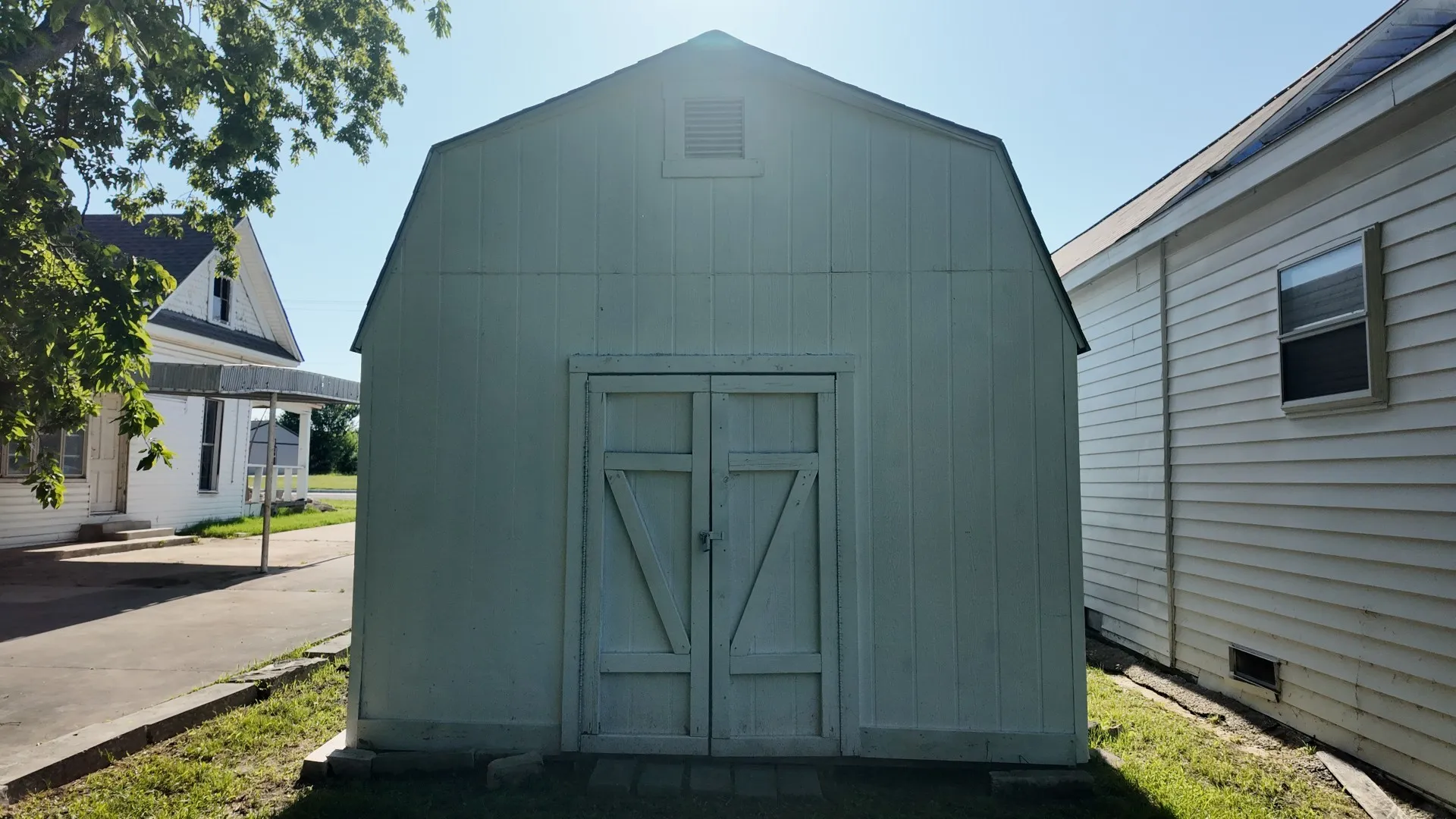 Gable roof shed featuring double barn doors and an upper vent