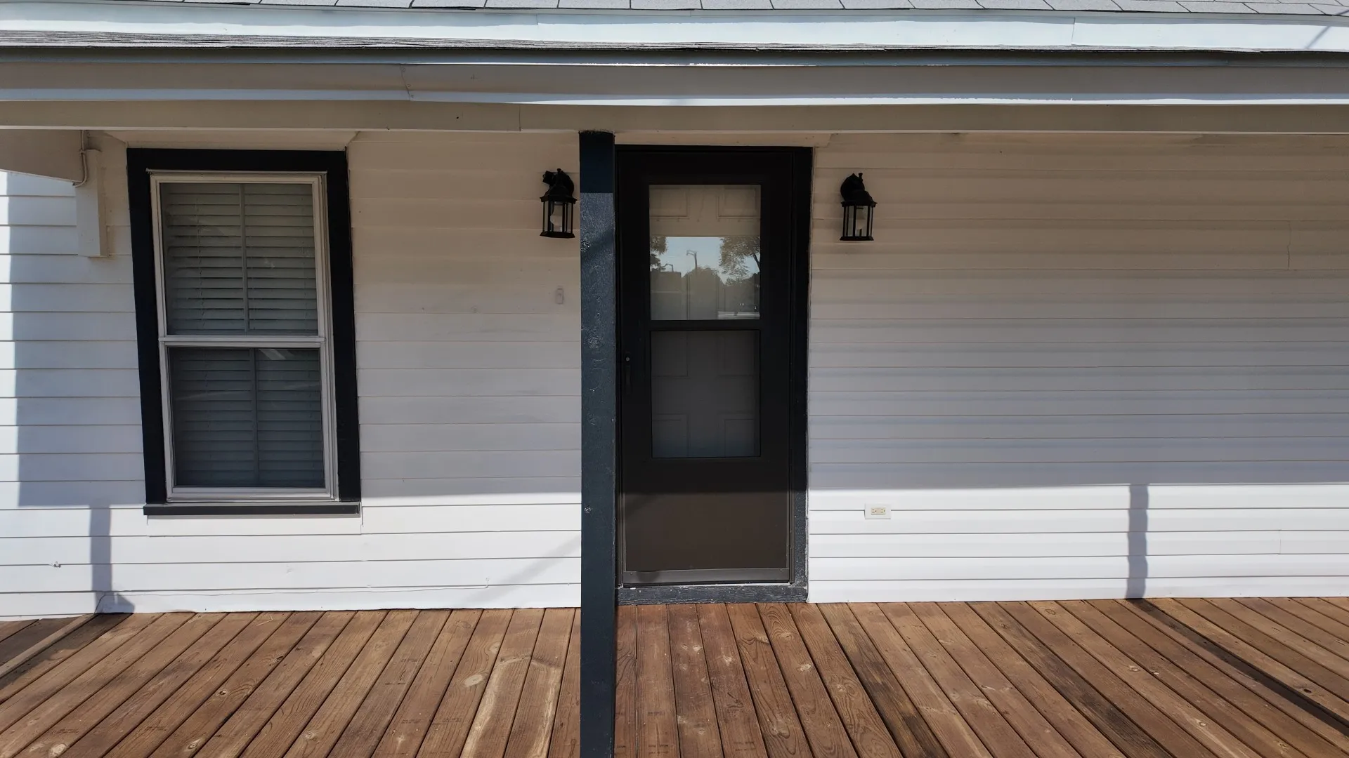 Hardwood decking with white siding and black trim