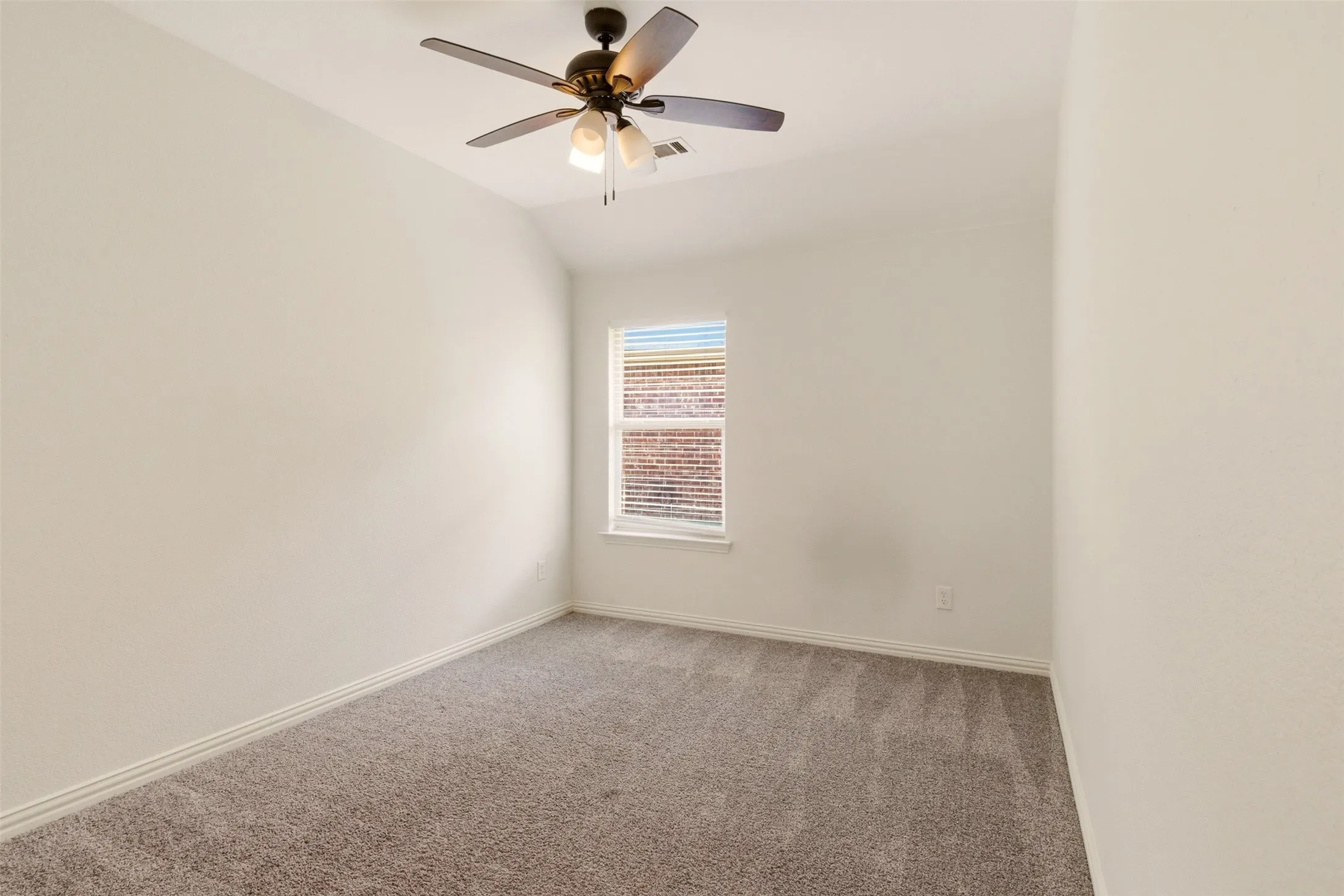 Plush carpeting, window with blinds, ceiling fan with integrated lighting, and neutral wall finishes