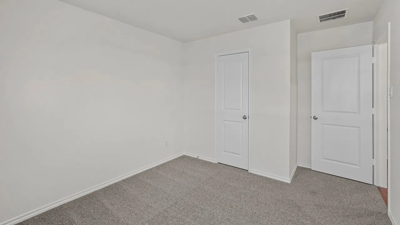 Neutral wall paint, gray carpet flooring, and white interior doors