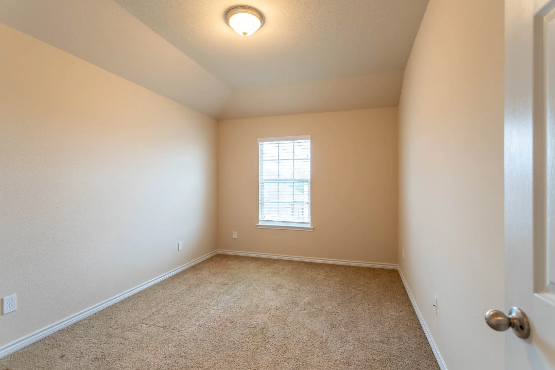 Recessed window with blinds, carpeted flooring, and a ceiling-mounted light fixture
