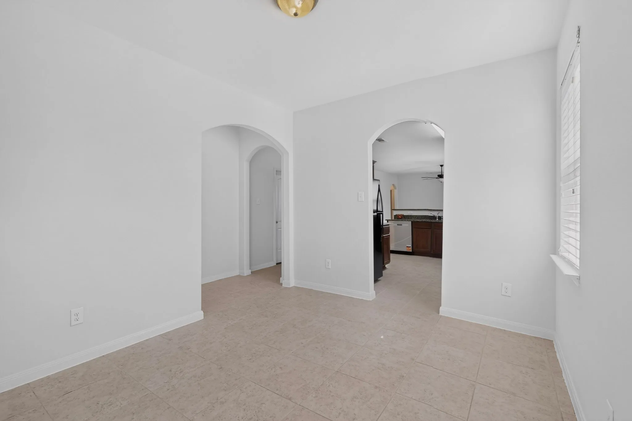 Light-toned tile flooring throughout with arched doorways