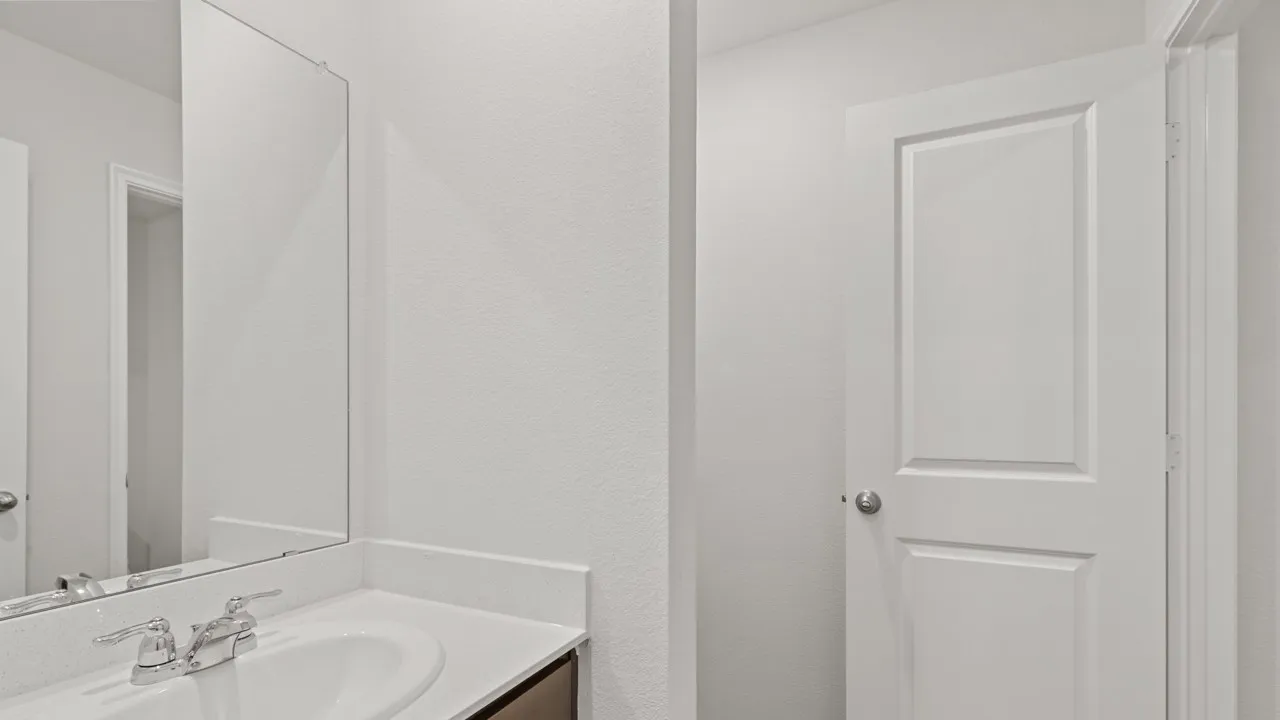 Vanity area featuring a rectangular undermount sink, chrome faucet, and expansive wall-mounted mirror