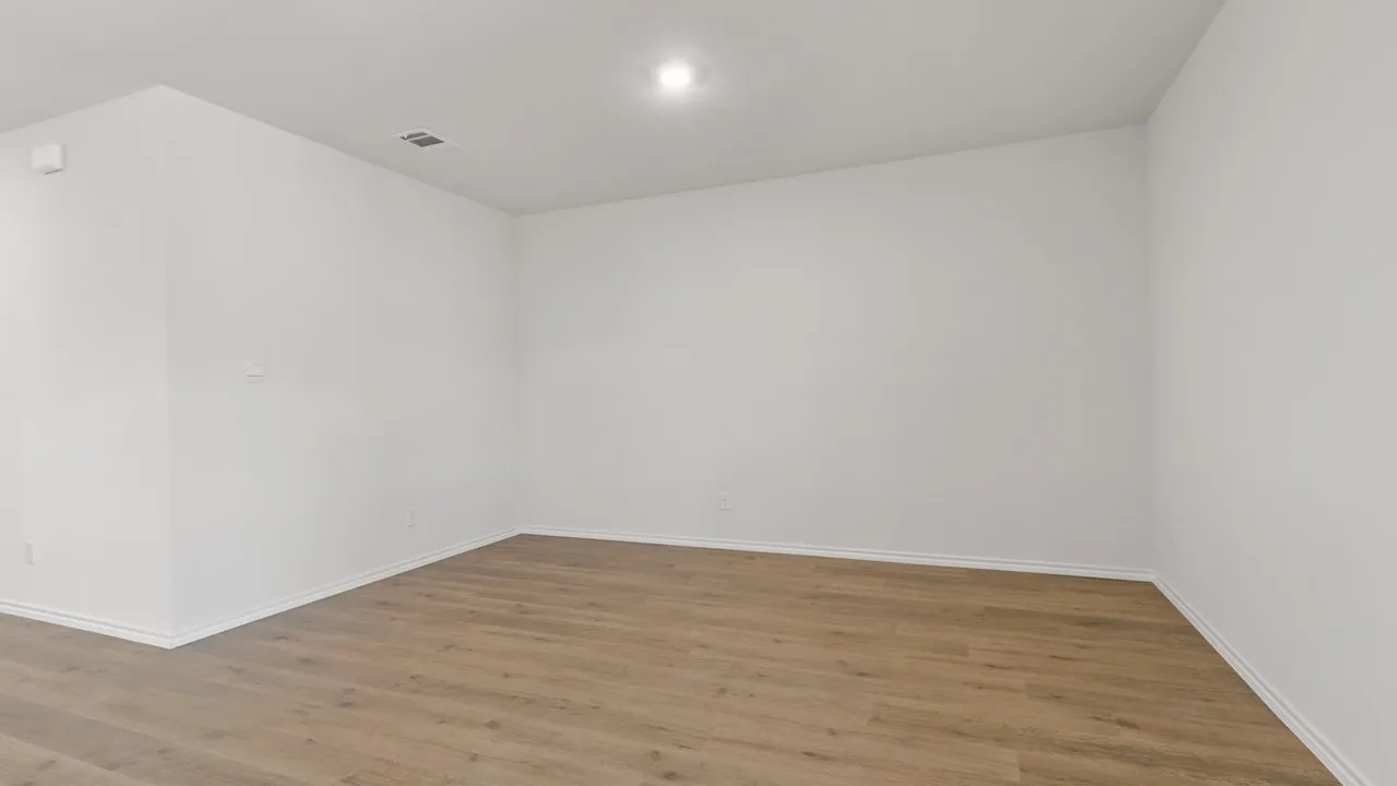 Spacious room featuring light wood-finish flooring, white baseboards, bright white walls, and recessed lighting