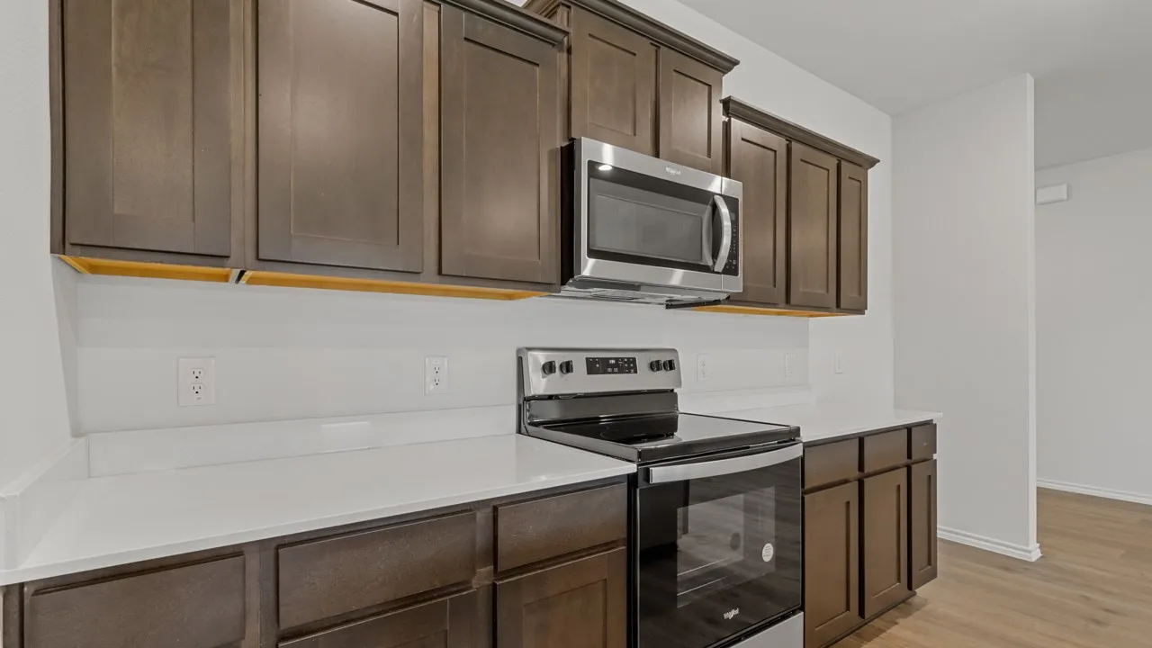 Kitchen featuring dark wood cabinetry, light-colored countertops, and a white subway tile backsplash