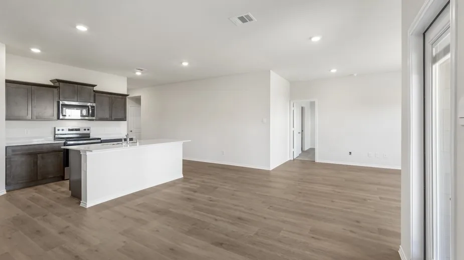 Open concept living area with wood-finish flooring, recessed lighting, and white walls