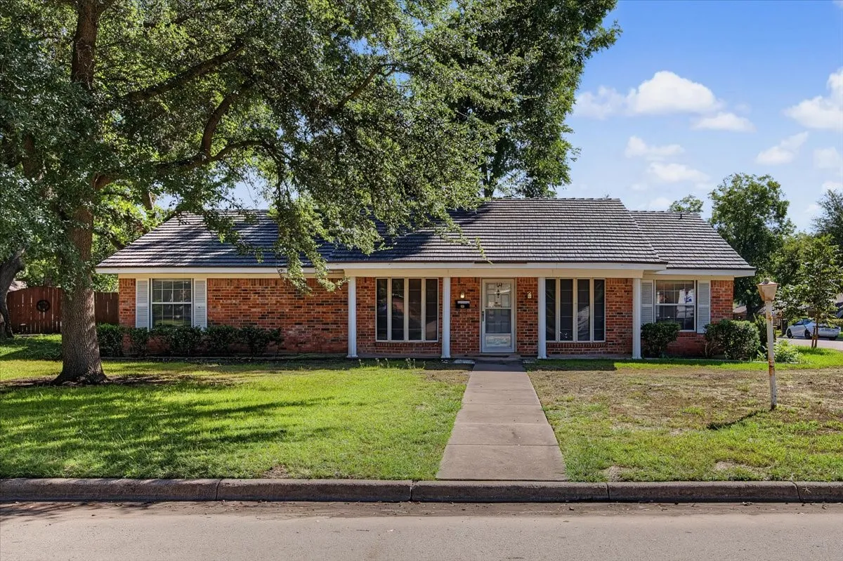 Brick exterior with a covered front porch supported by columns, featuring a gabled roofline