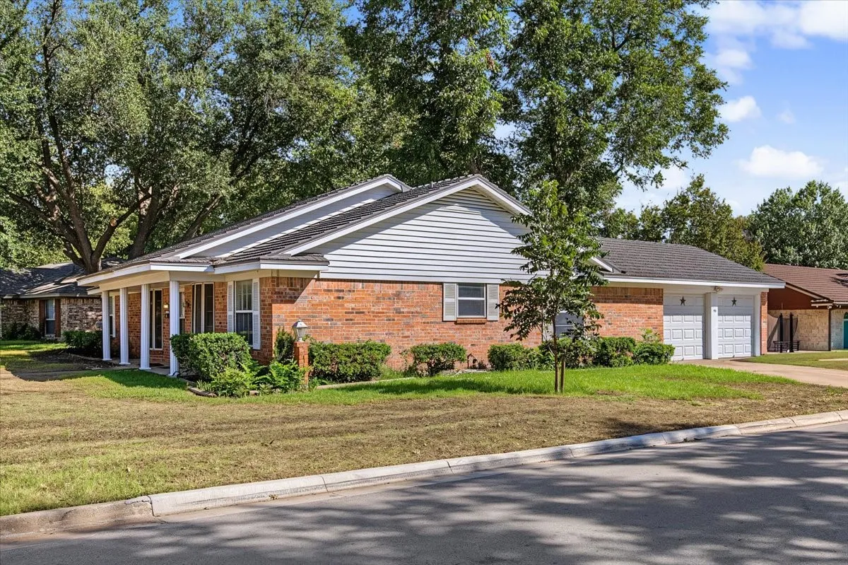 Brick exterior with white siding accents and a covered porch with white columns