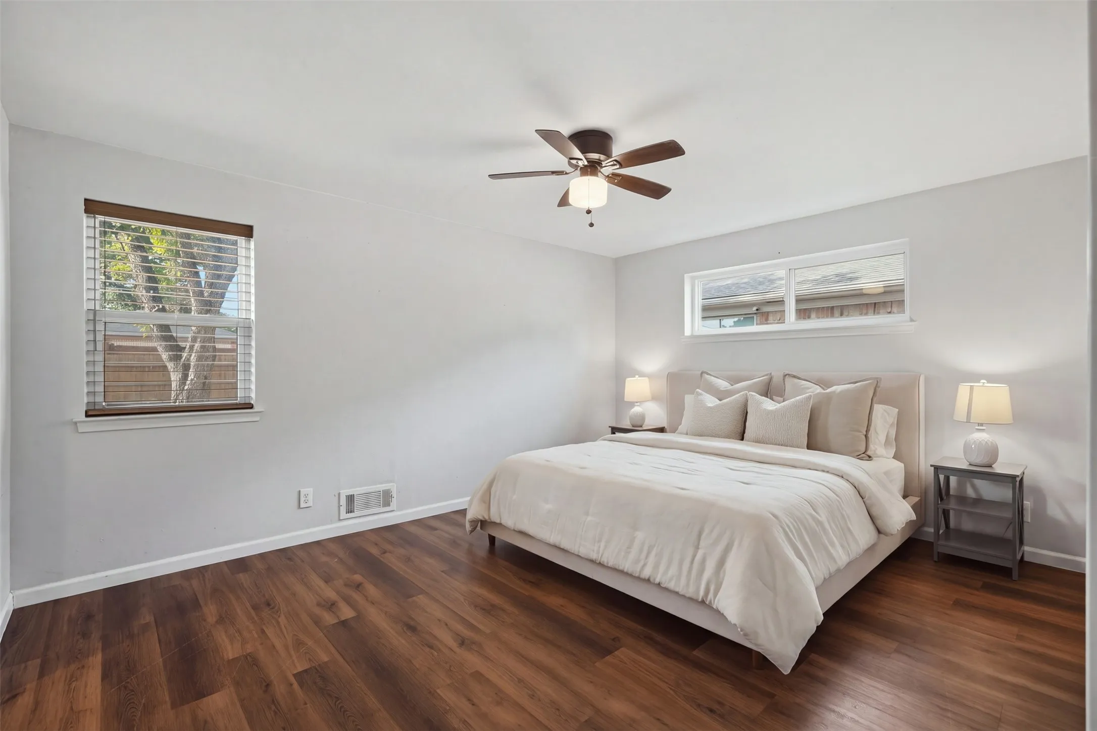 Primary bedroom with wood flooring