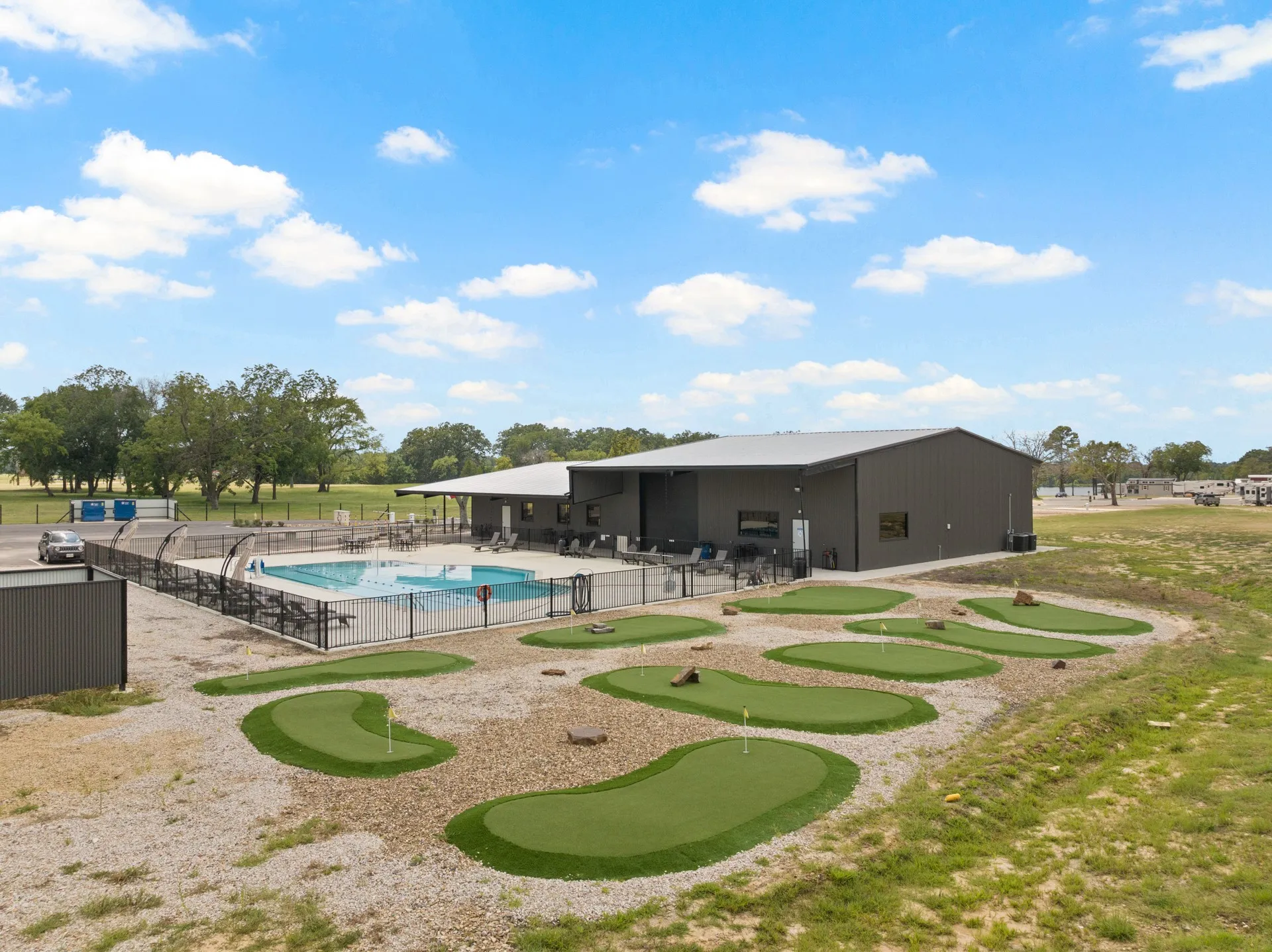 Community pool featuring a patio area and an area to practice putting