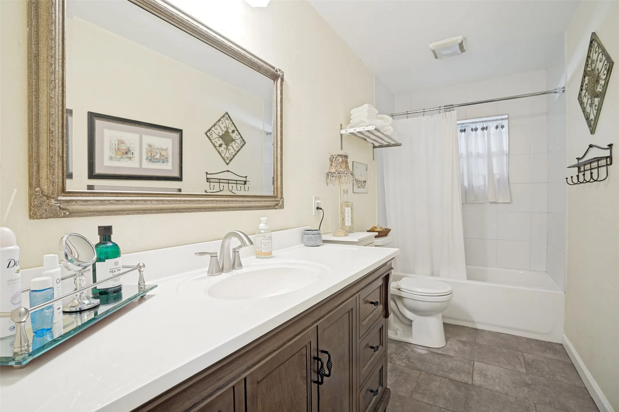 Hardwood-finish vanity with a white countertop, undermount sink, and brushed nickel faucet