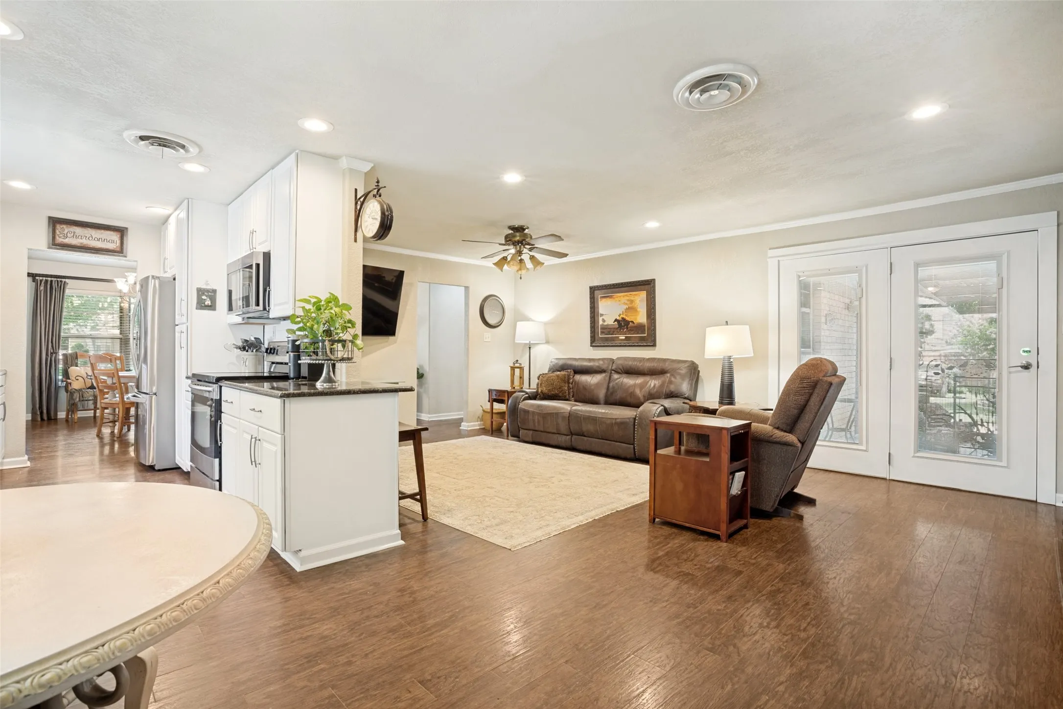 Wood-like flooring throughout, recessed lighting, and a ceiling fan