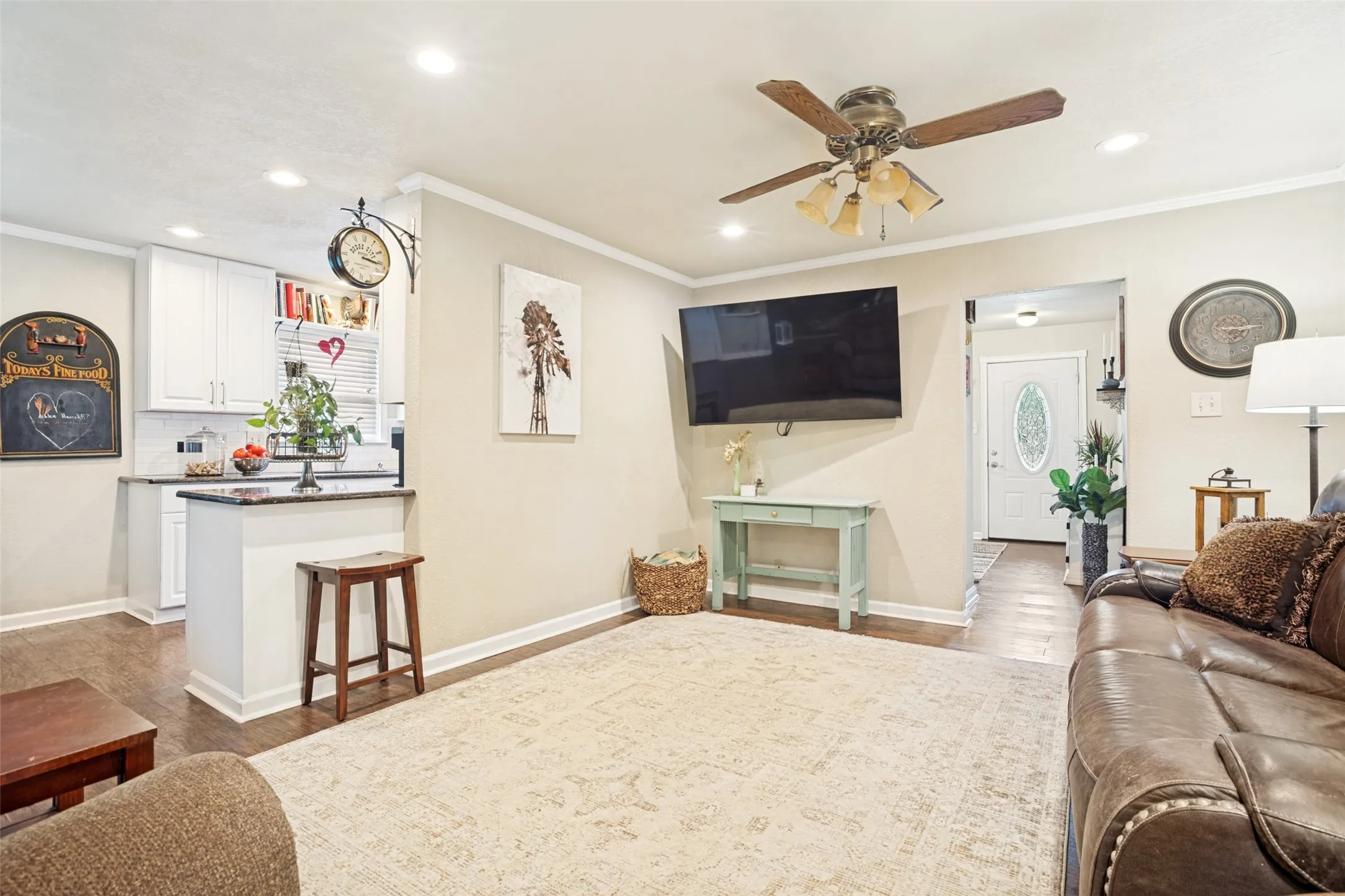 Open-concept living space with recessed lighting, wood-like flooring, and a ceiling fan