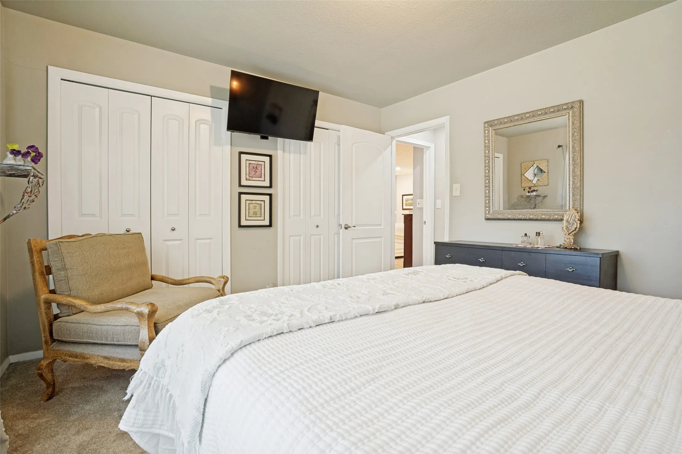Light-colored walls with white trim, bi-fold closet doors, and carpet flooring