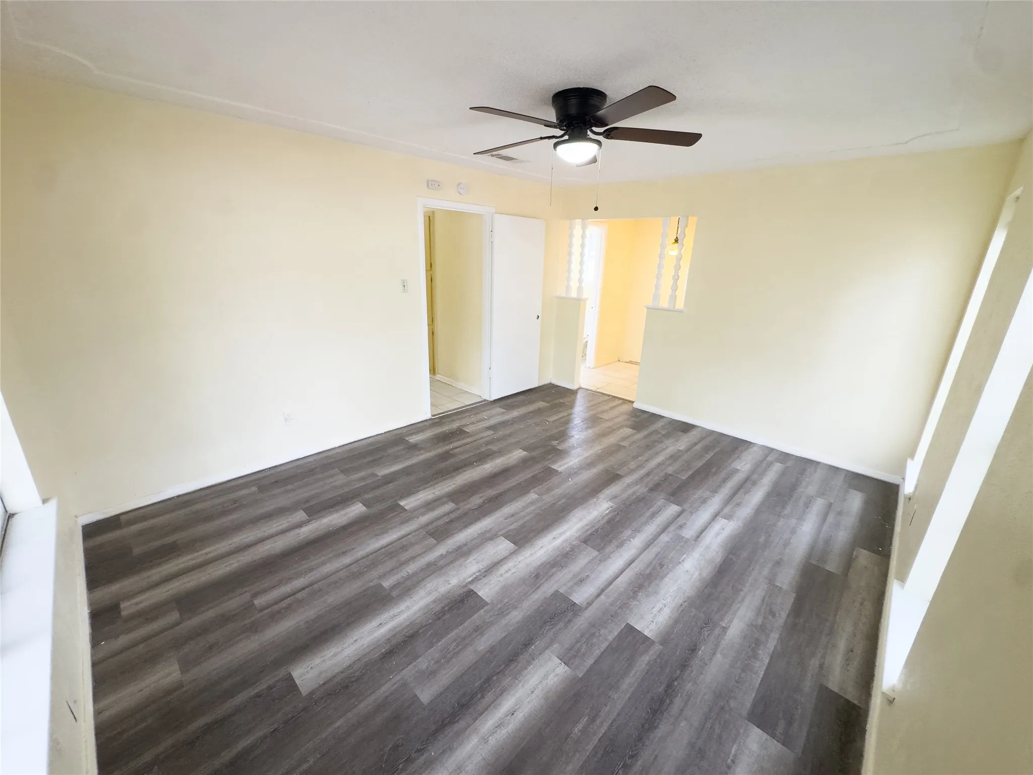 Wood-finish flooring throughout, complemented by a ceiling fan with integrated lighting