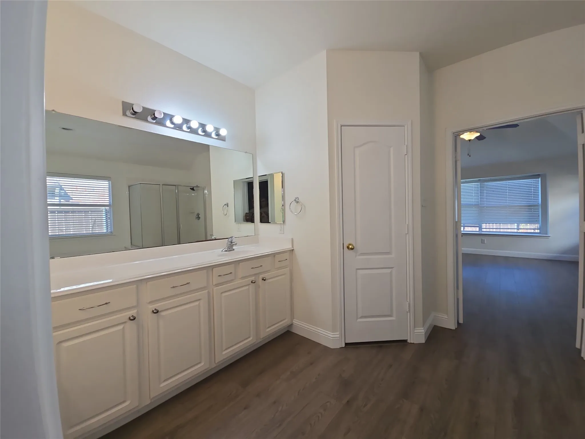 Dual vanity with a single sink, an expansive wall mirror, and a built-in medicine cabinet
