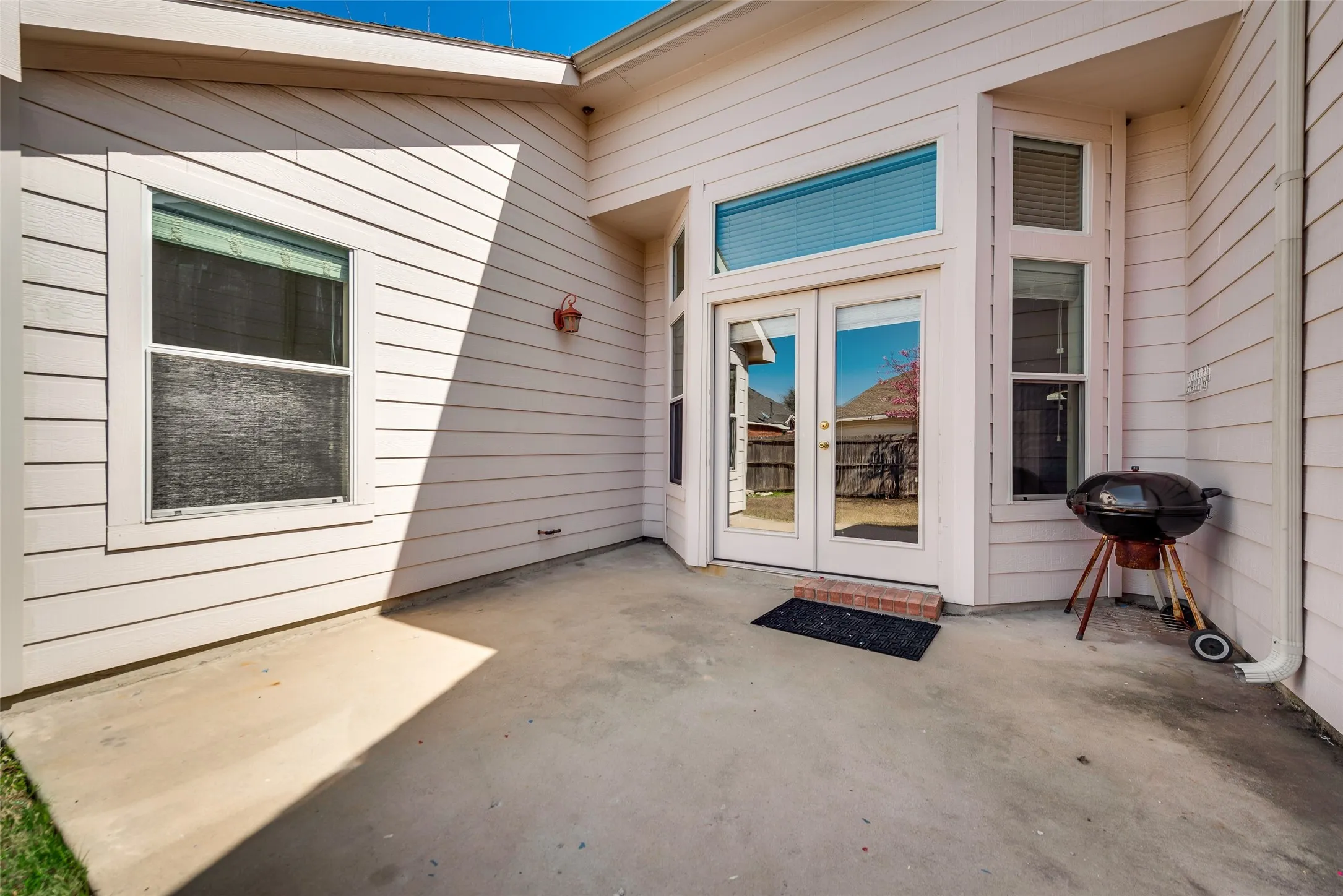 Concrete patio with a white siding exterior