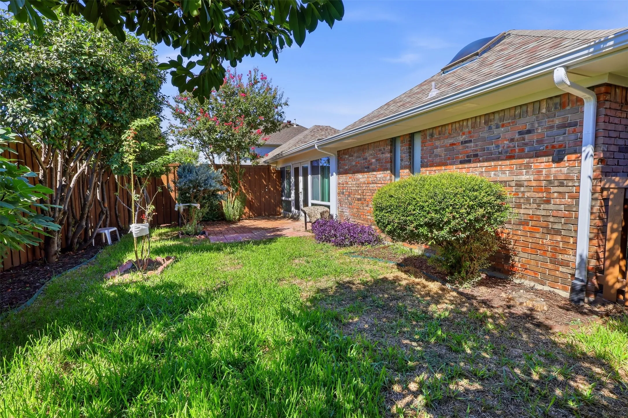 Brick exterior with white gutters and a shingle roof
