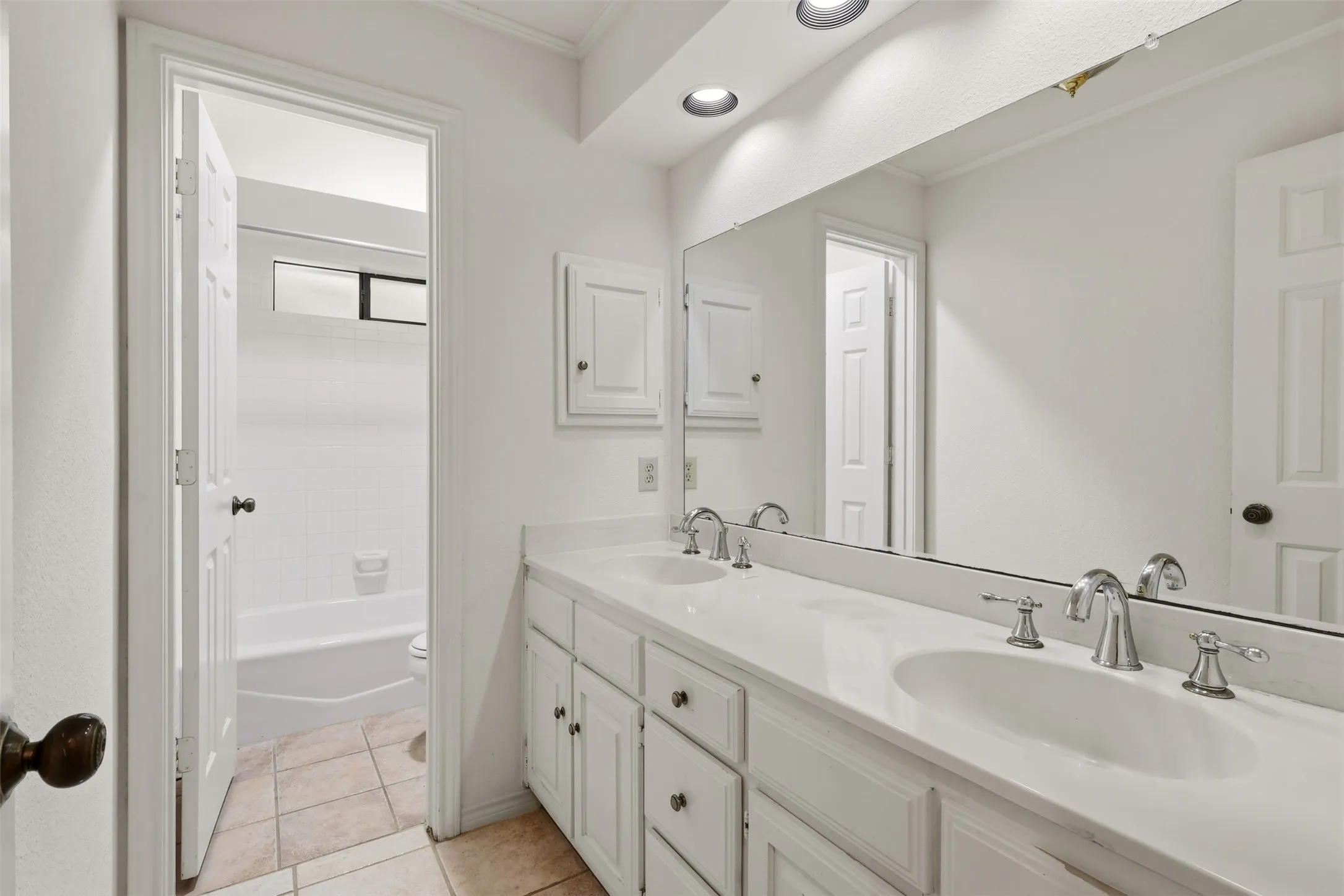 Double vanity with integrated sinks, chrome fixtures, recessed lighting, and tiled flooring