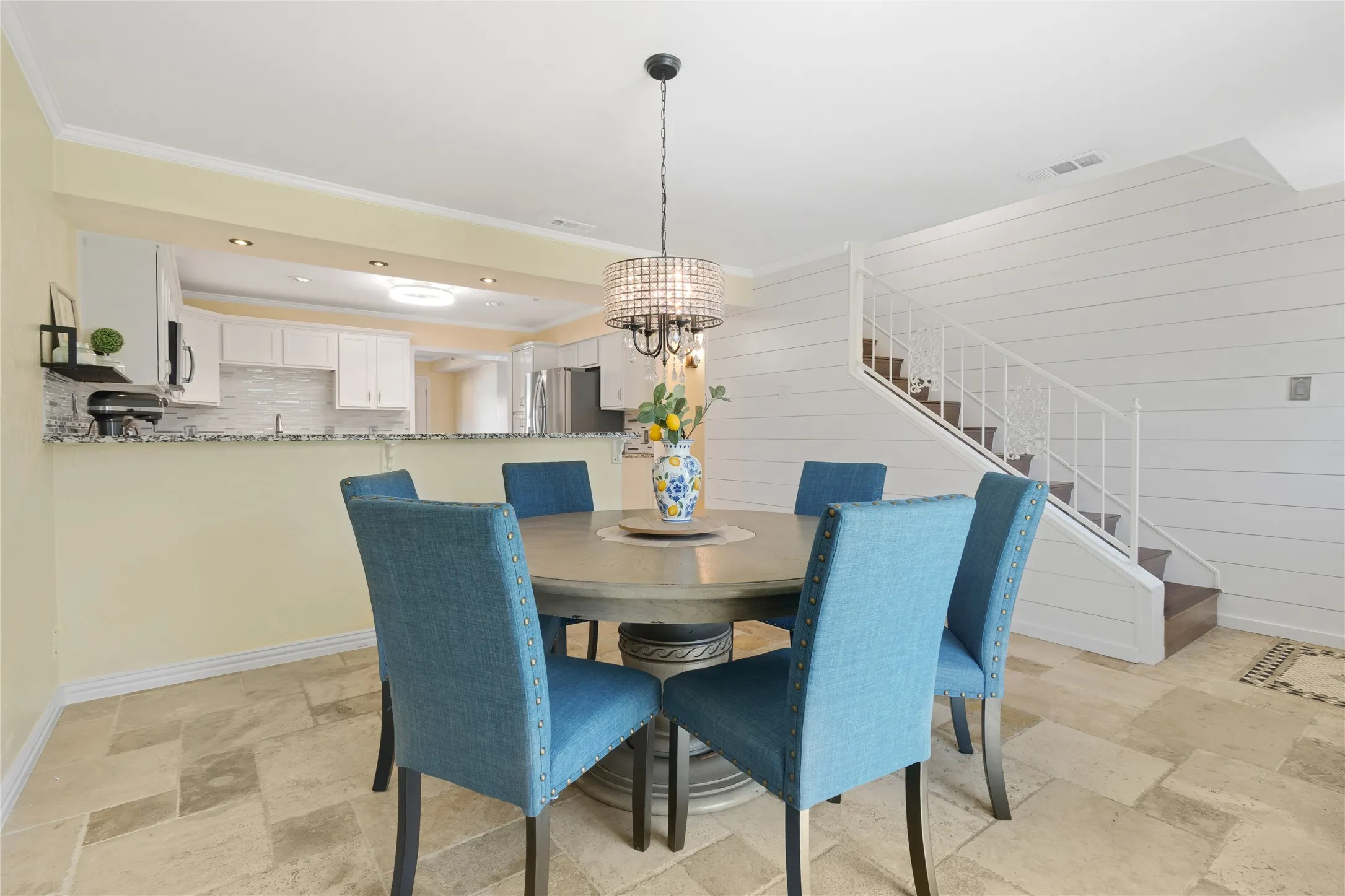 Open-concept dining area with tile flooring and a decorative chandelier
