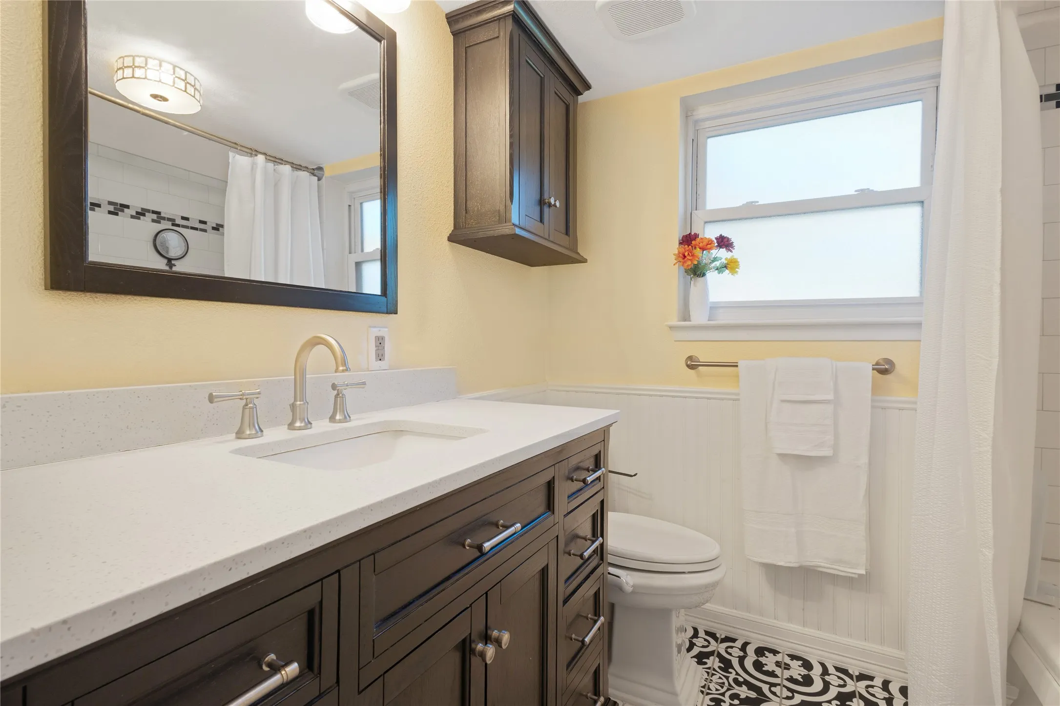 Dark wood-finish vanity with a light-toned countertop and an undermount sink