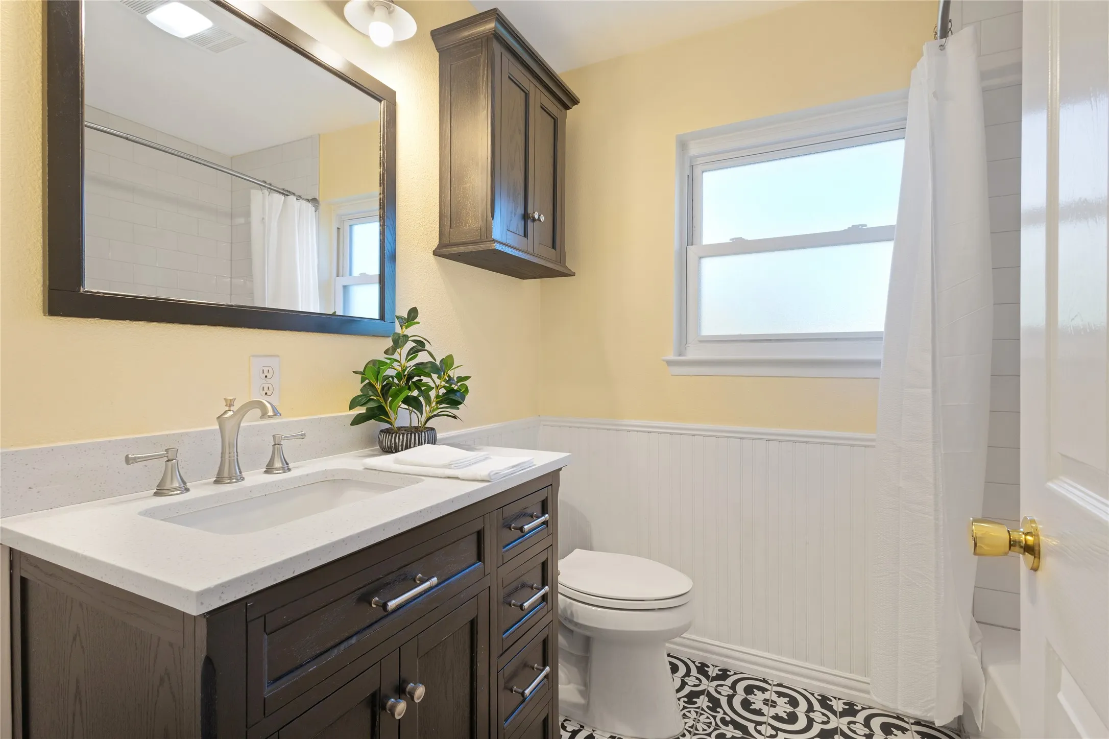 Dark wood-finish vanity with a light-colored countertop and integrated sink