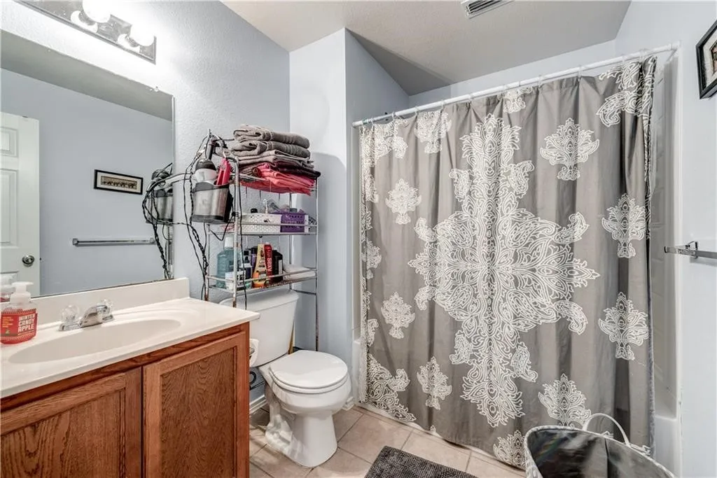 Wood-finish vanity with an integrated sink, polished chrome faucet, and overhead bar lighting