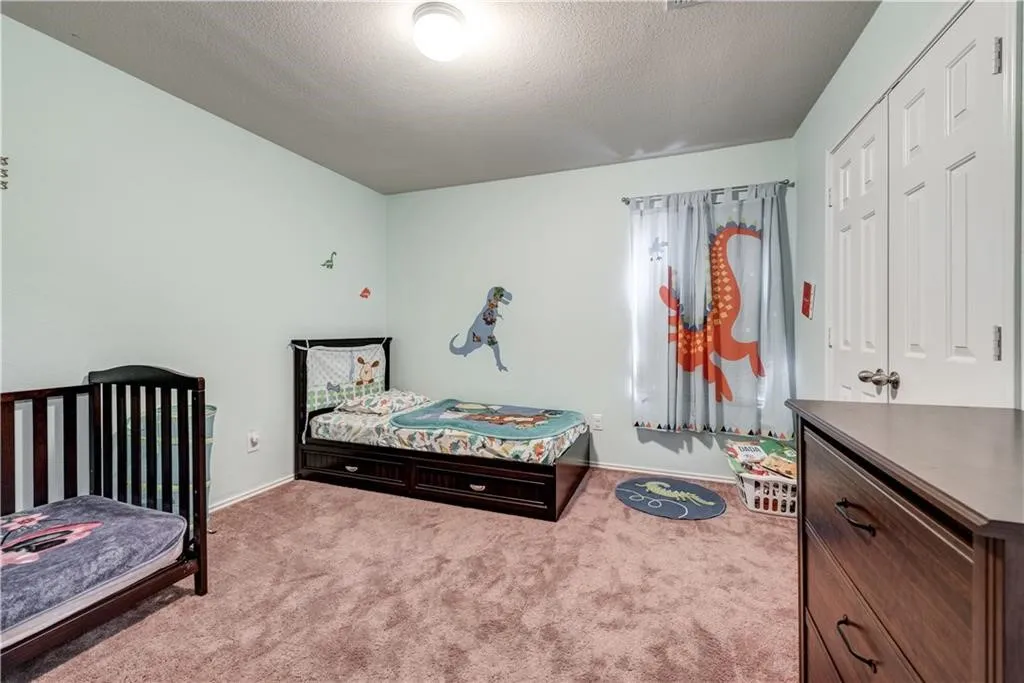 Neutral wall color, carpeted flooring, window with curtain rod, and white bi-fold closet doors